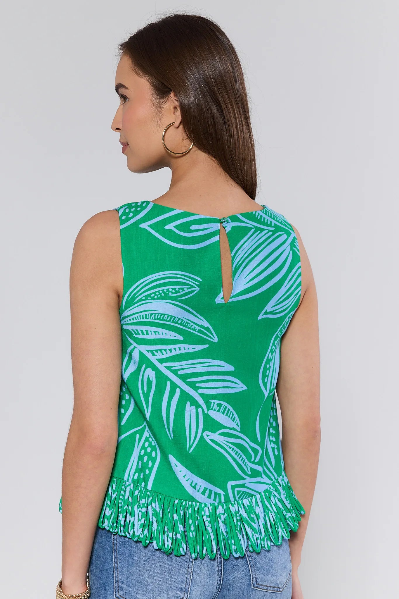 green sleeveless top with leaf pattern and fringes on a plain background