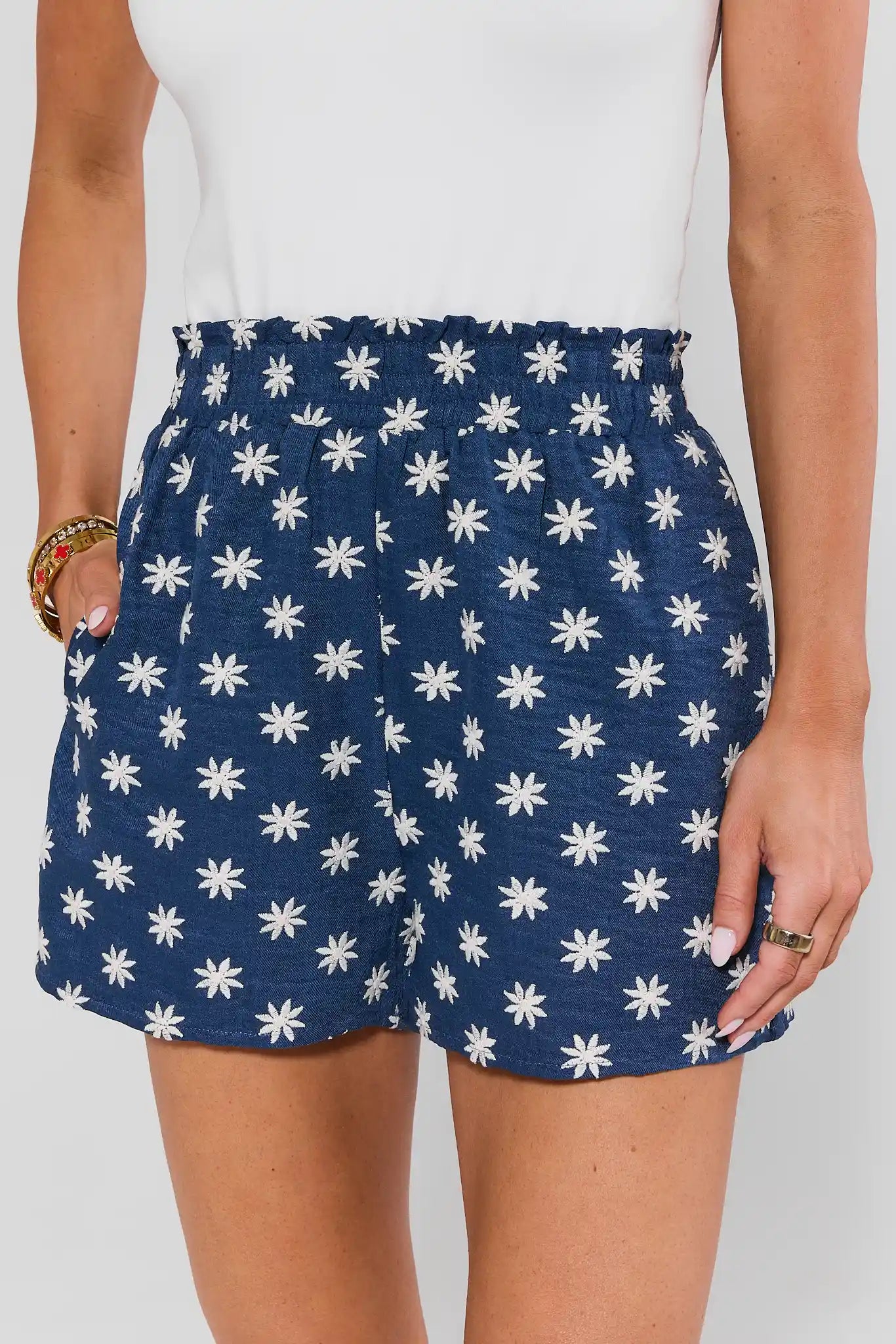 Navy blue skirt with white floral pattern worn by a person on a plain background