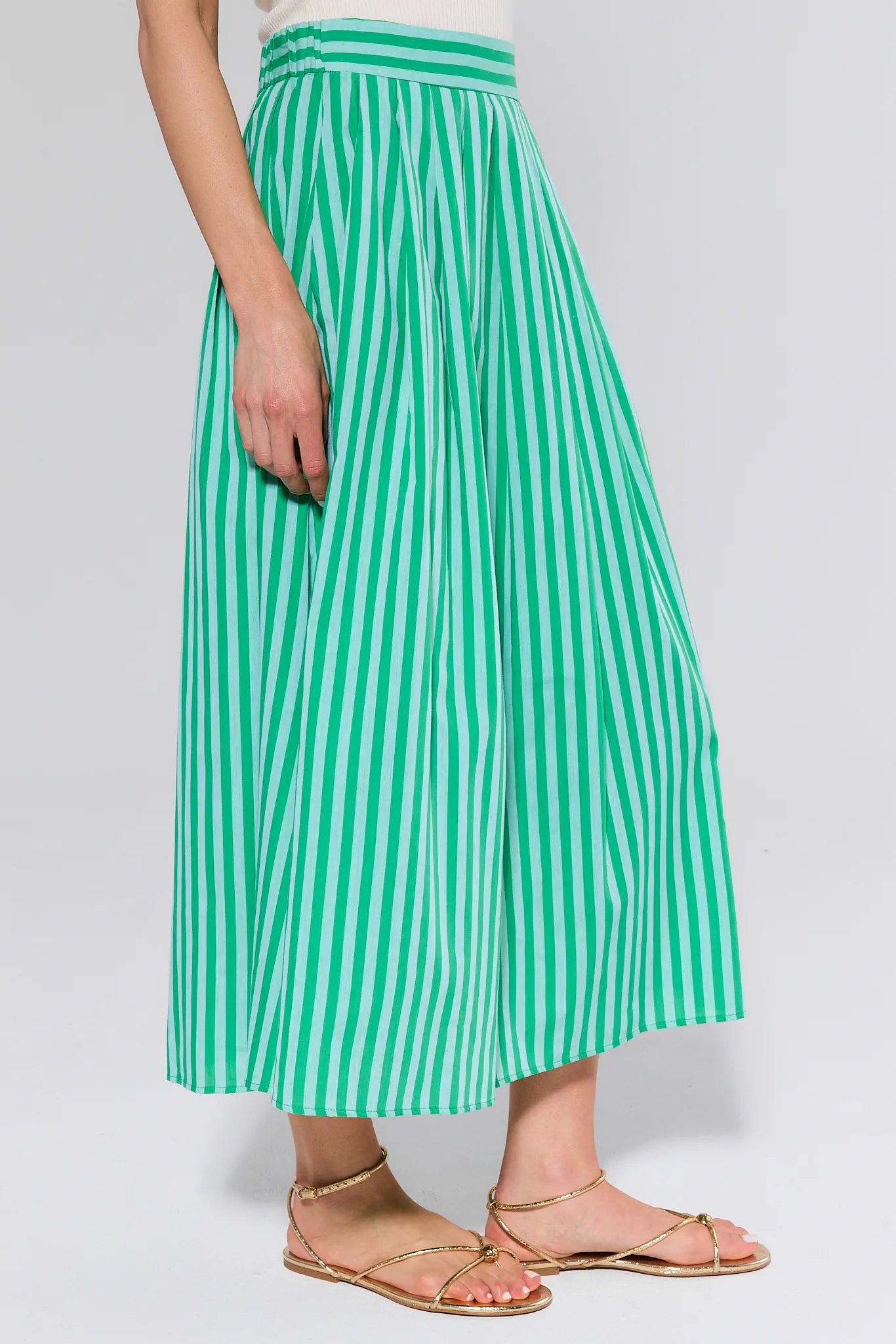 women wearing green and green stripe skirt on white background