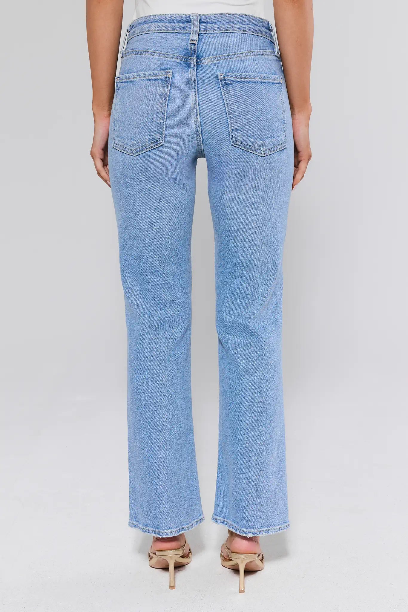 Light blue jeans worn by a person on a white background