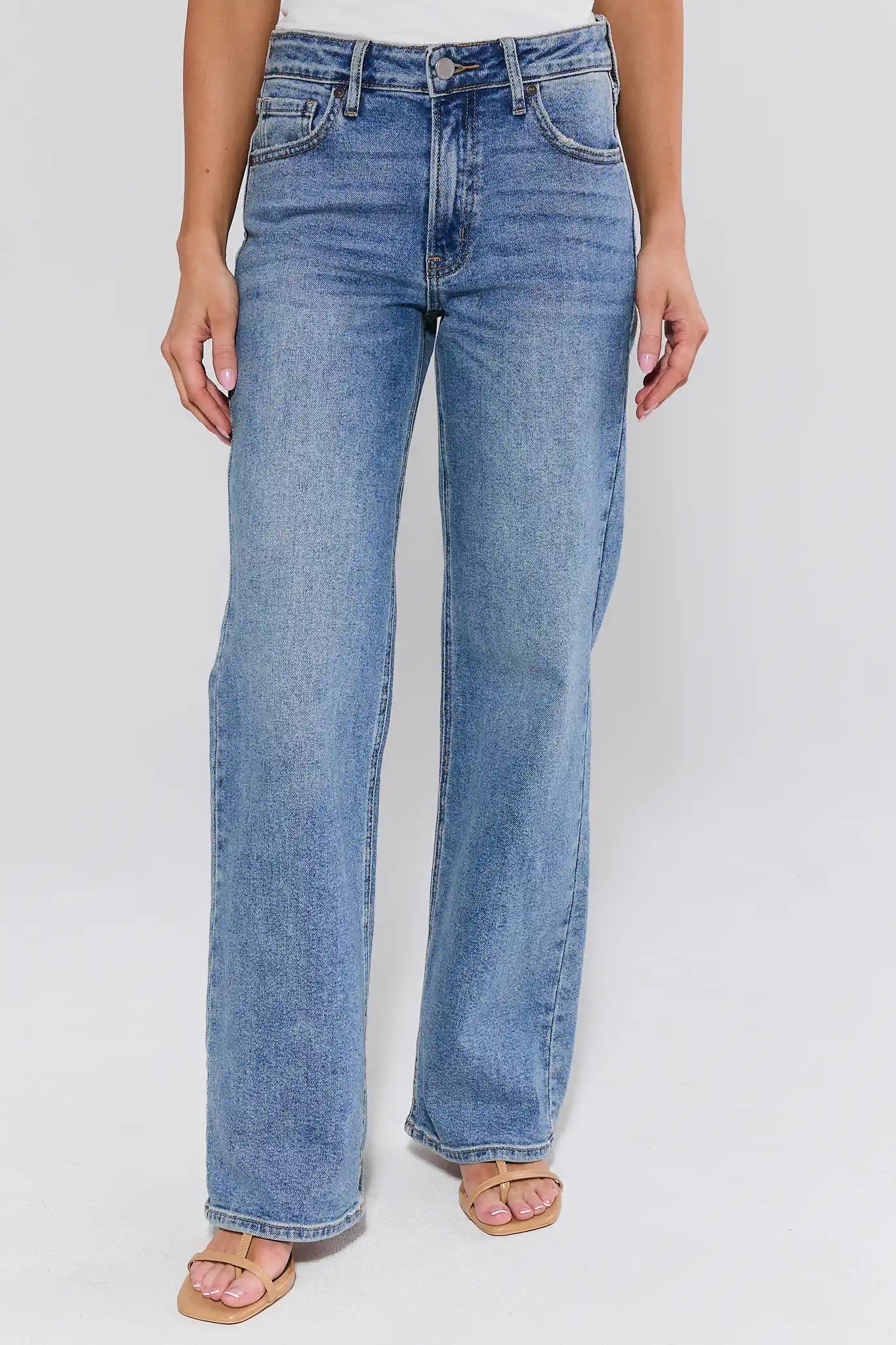 Blue jeans worn by a person on a white background