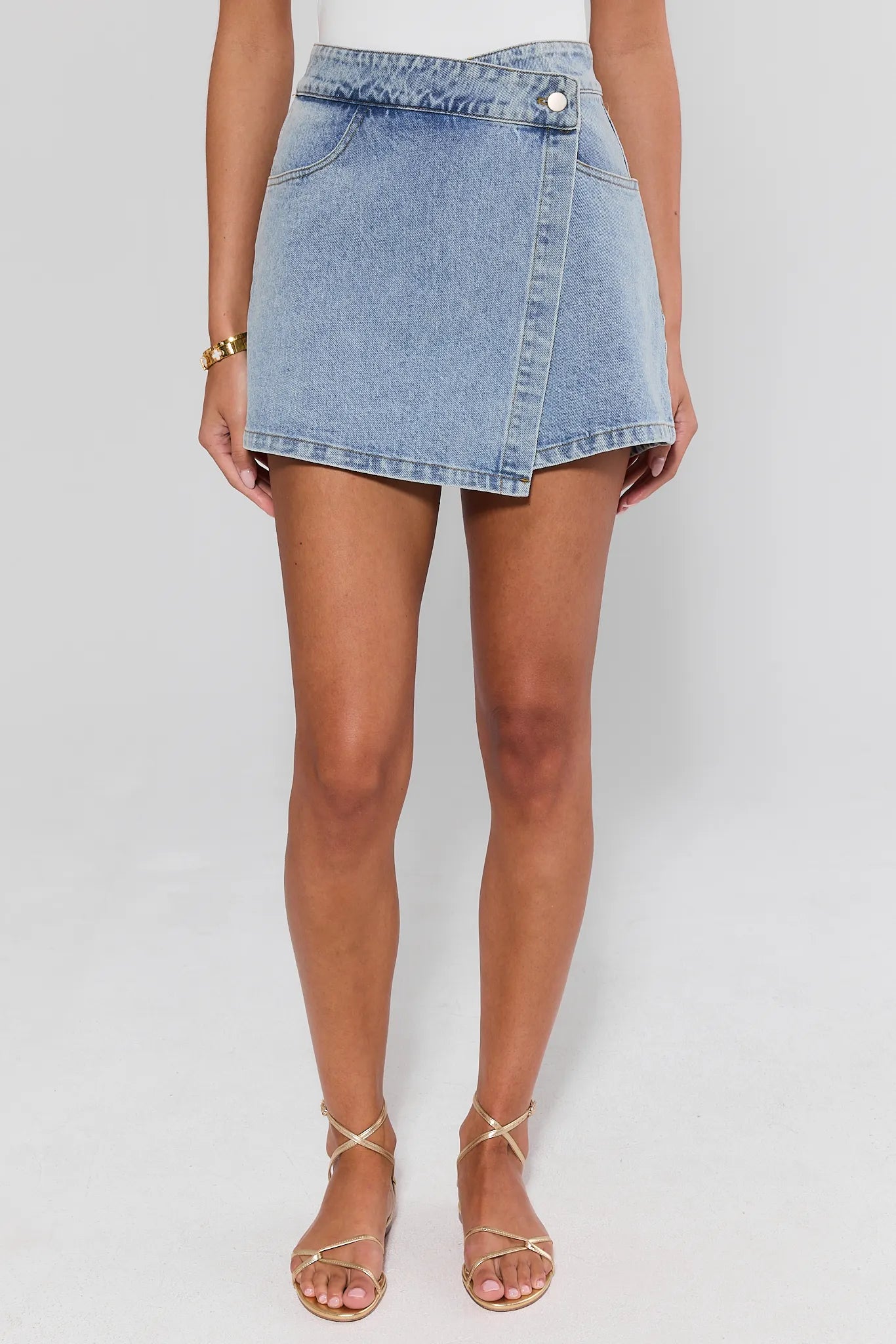 Denim wrap skirt worn by a person on a plain background
