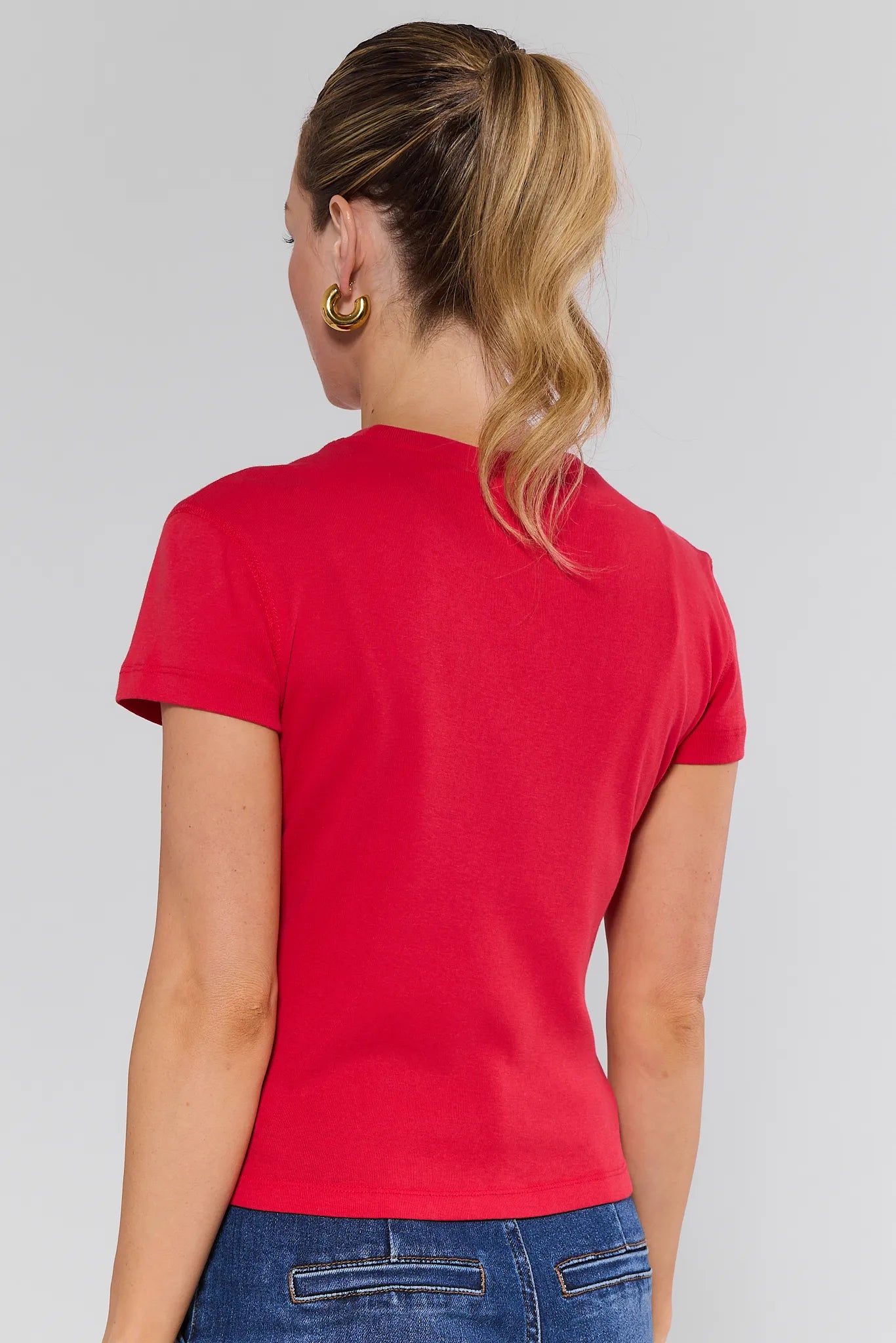 Woman wearing a Aria Tee- Red and leopard print belt on a plain background