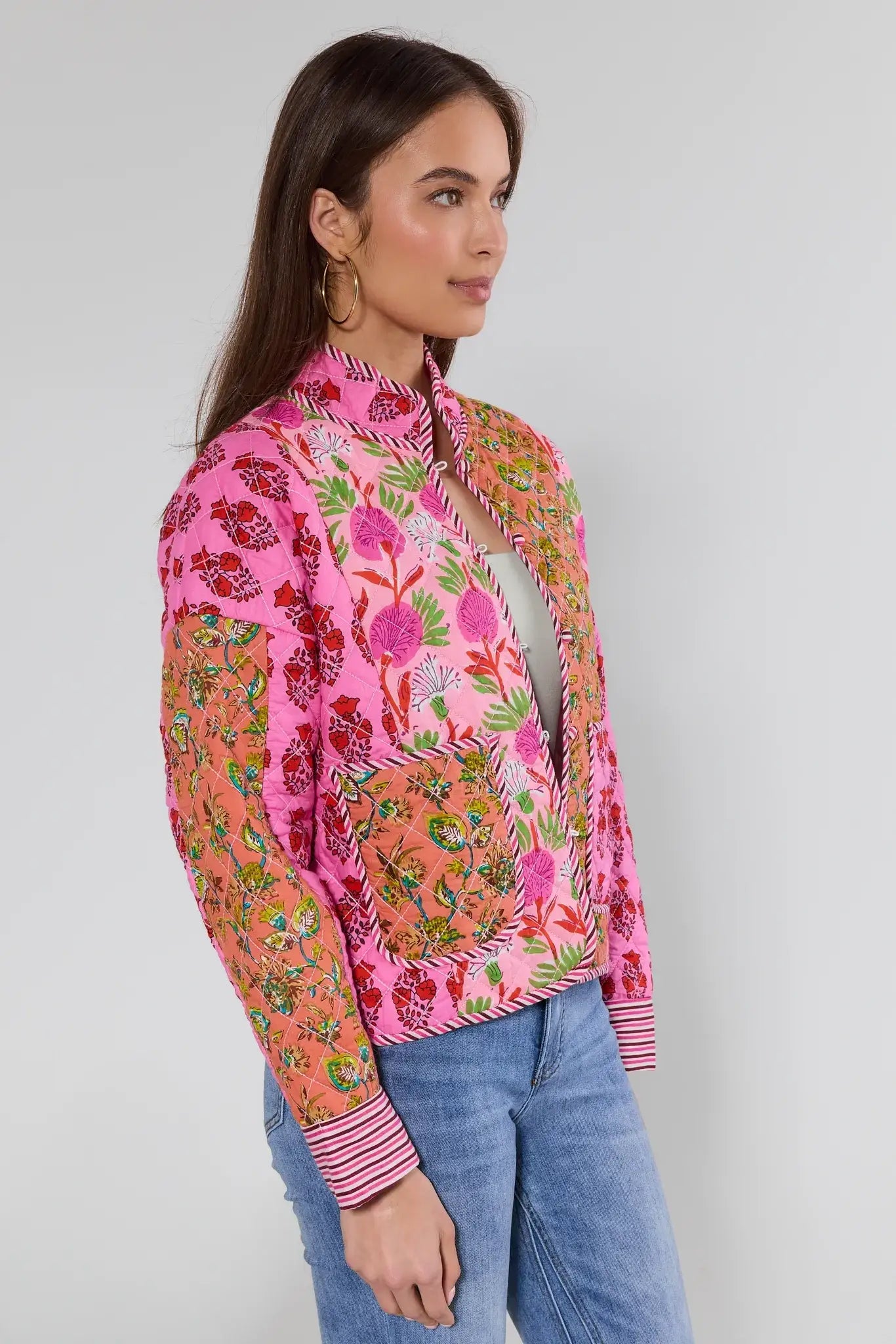 Woman wearing a colorful floral patterned shirt against a plain background