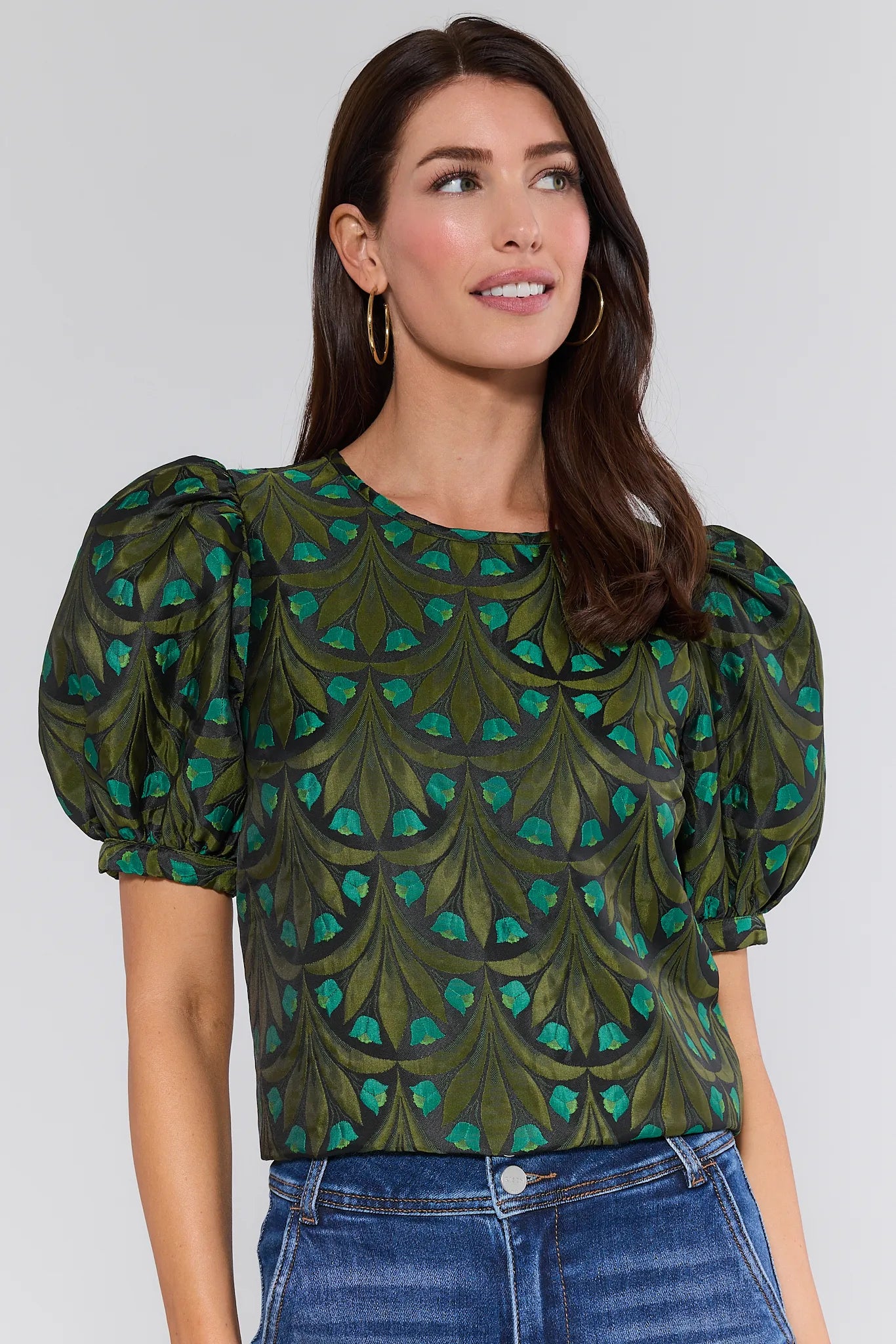 Woman wearing a green patterned Raquel Top with puffed sleeves against a white background