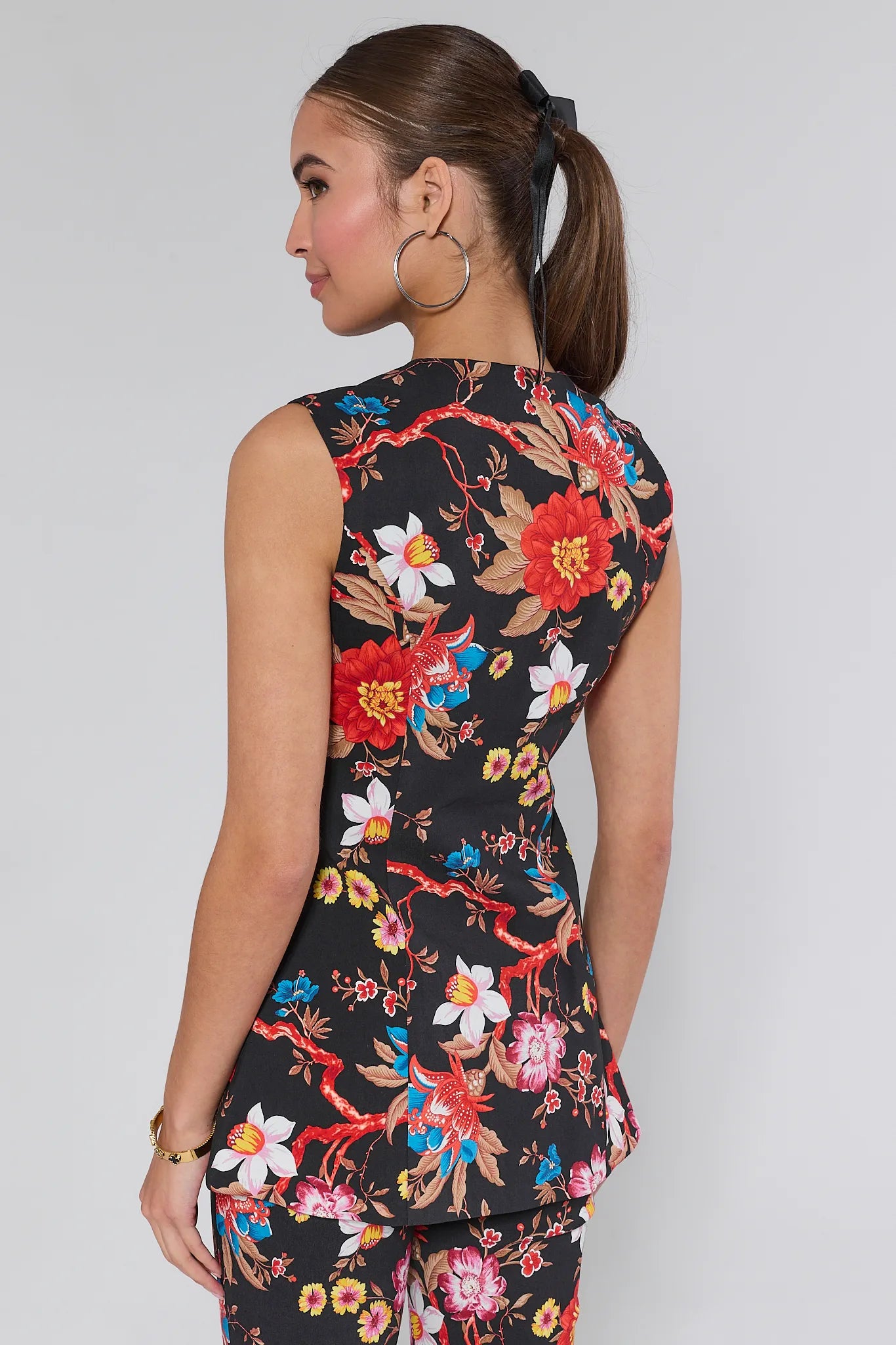 Woman wearing a sleeveless fAnnie Mixed Floral Tailored Top against a white background