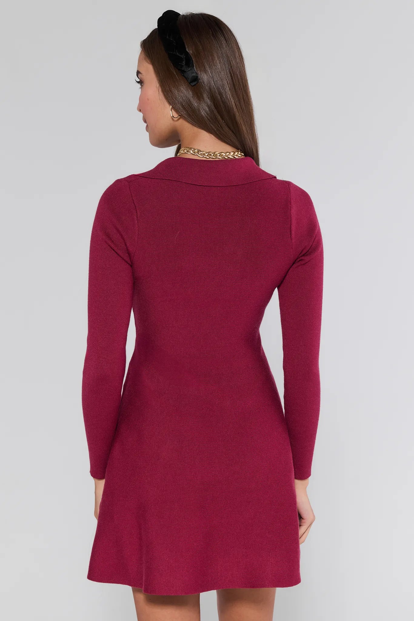 Woman wearing a burgundy Amelia Dress with long sleeves on a white background
