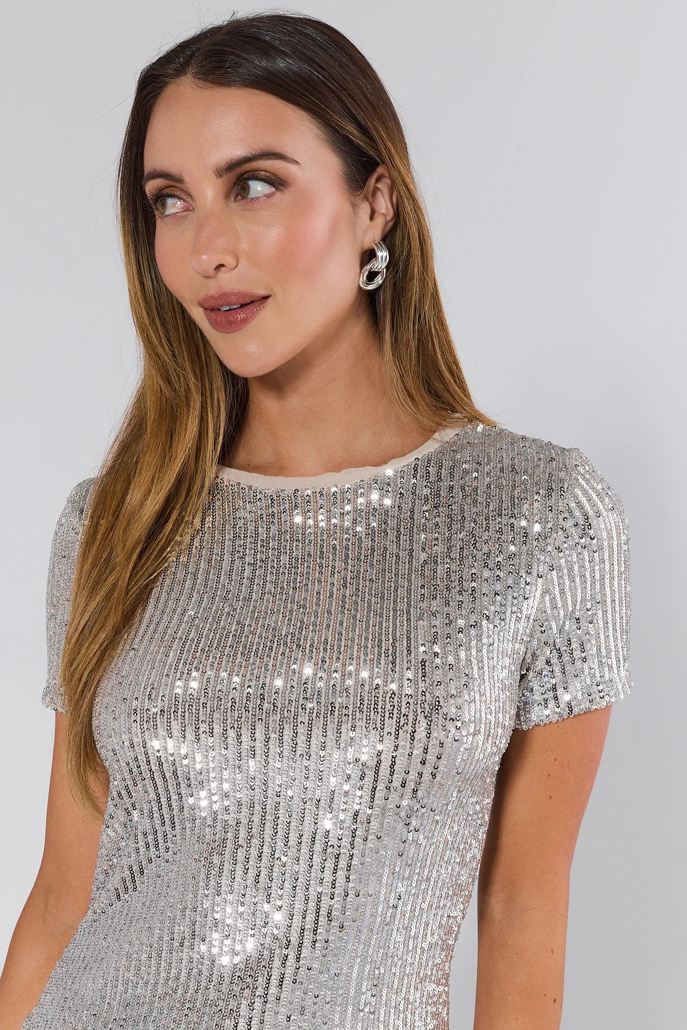 Woman wearing a Hannah Silver Sequin Top against a plain background