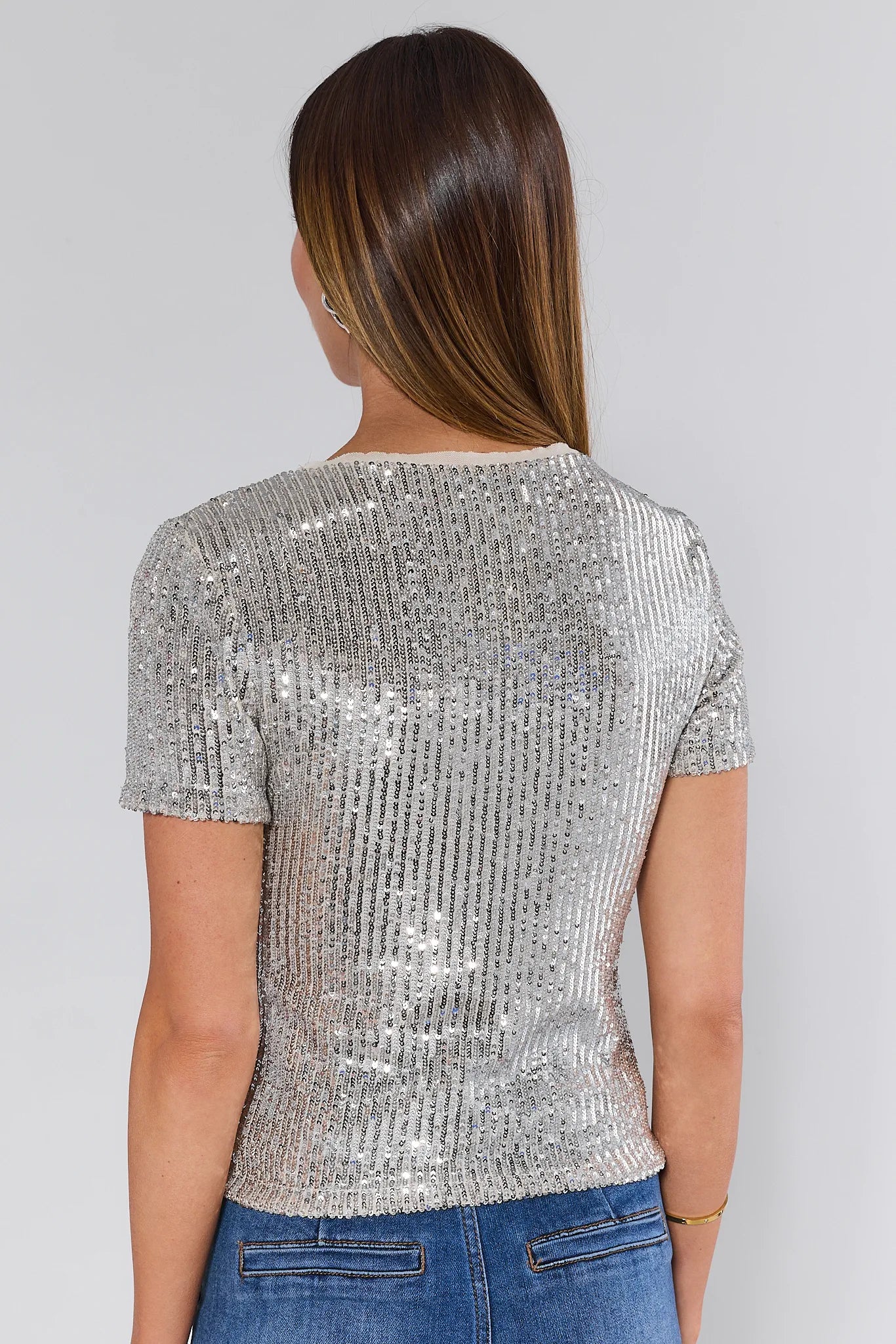 Woman wearing a Hannah Silver Sequin Top against a plain background