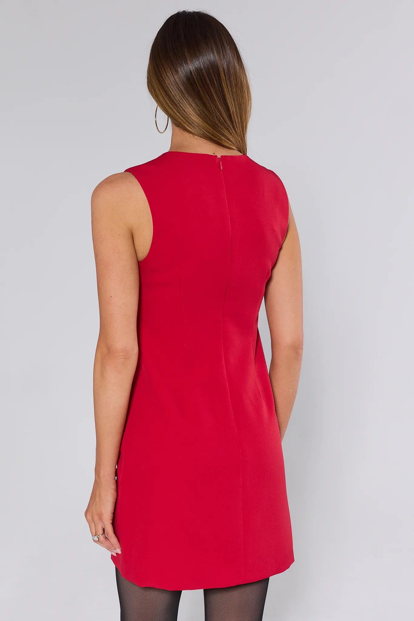 Woman wearing a red Miranda dress with bow sides on a white background