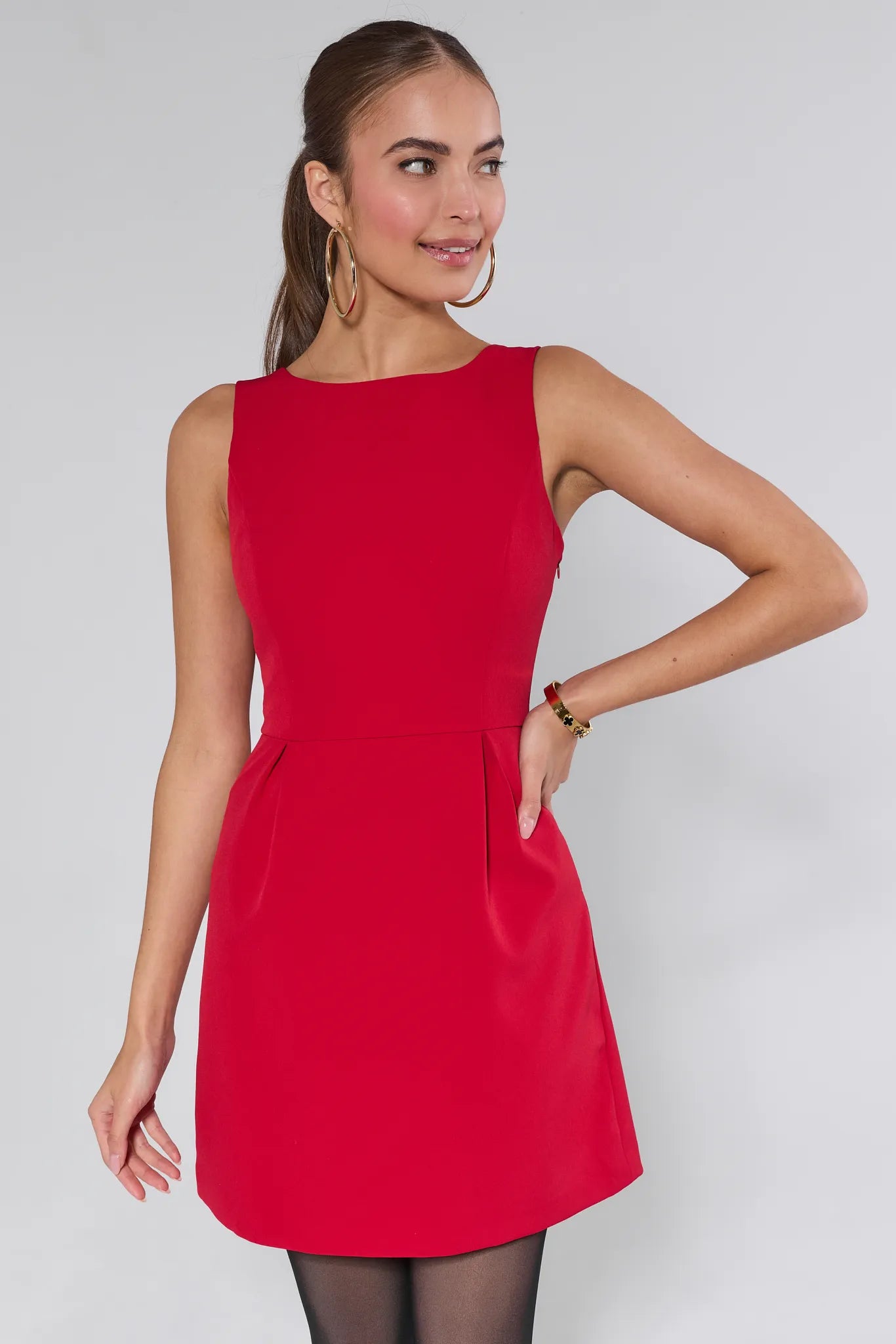 Woman wearing a red Nina dress against a plain background
