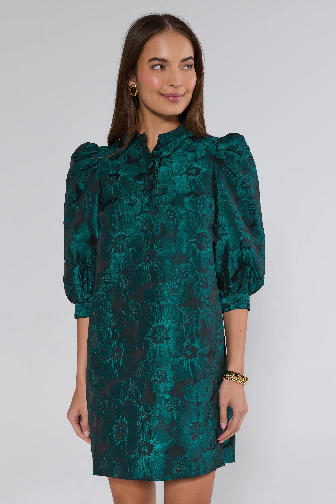 Woman wearing a green floral dress against a white background