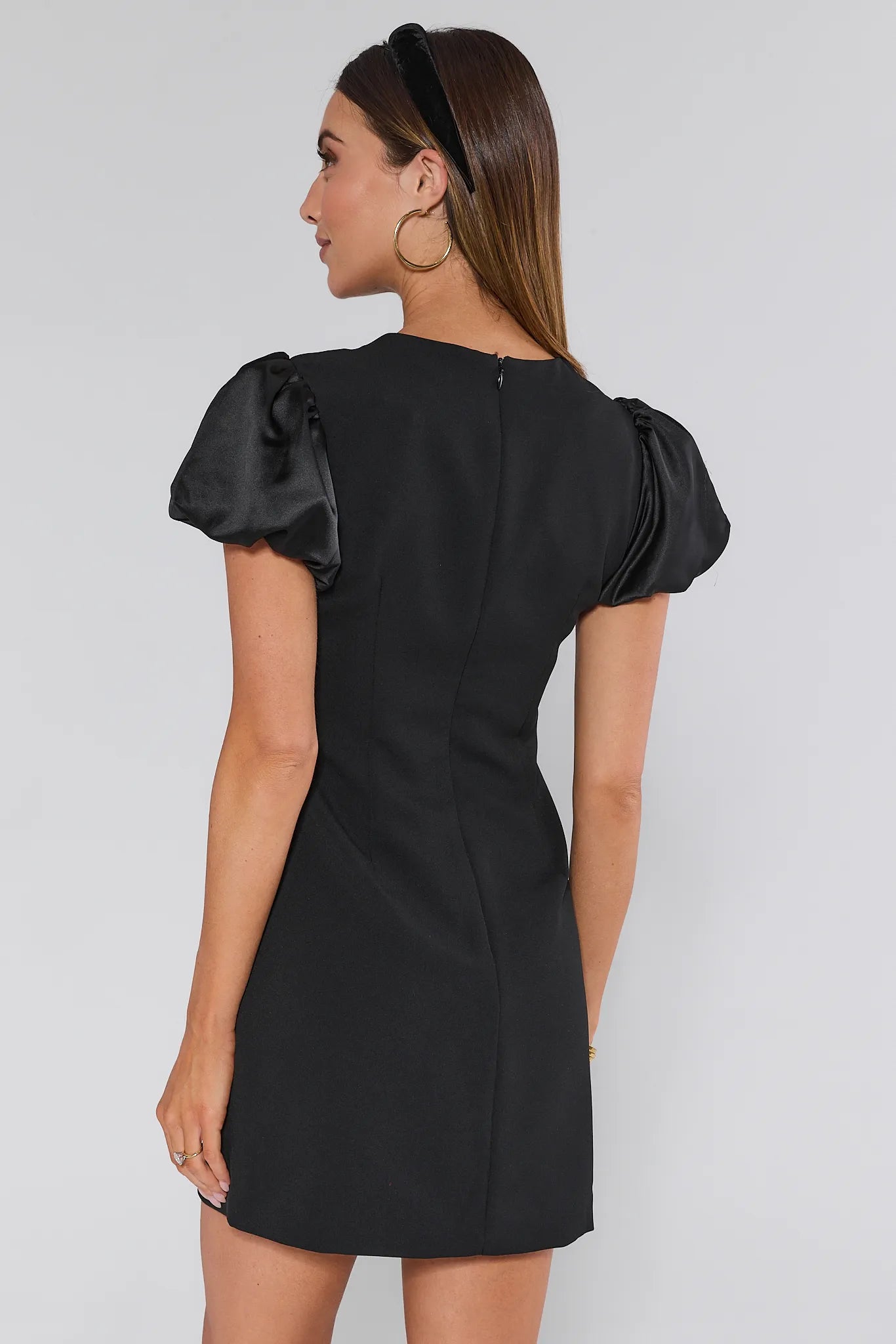 Black Anna dress with ruffled sleeves and a bow detail on a plain background