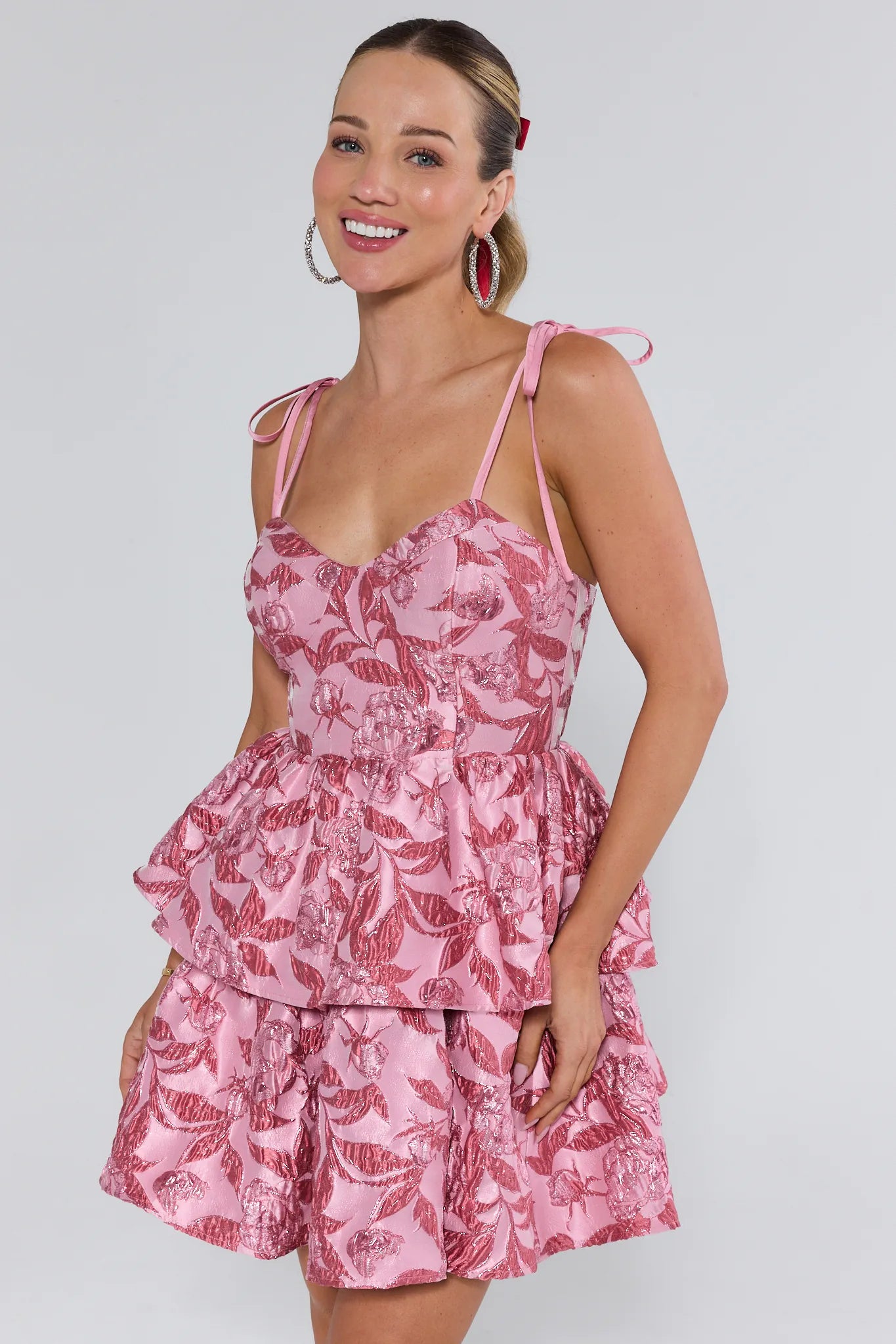 Woman wearing a pink floral dress against a white background
