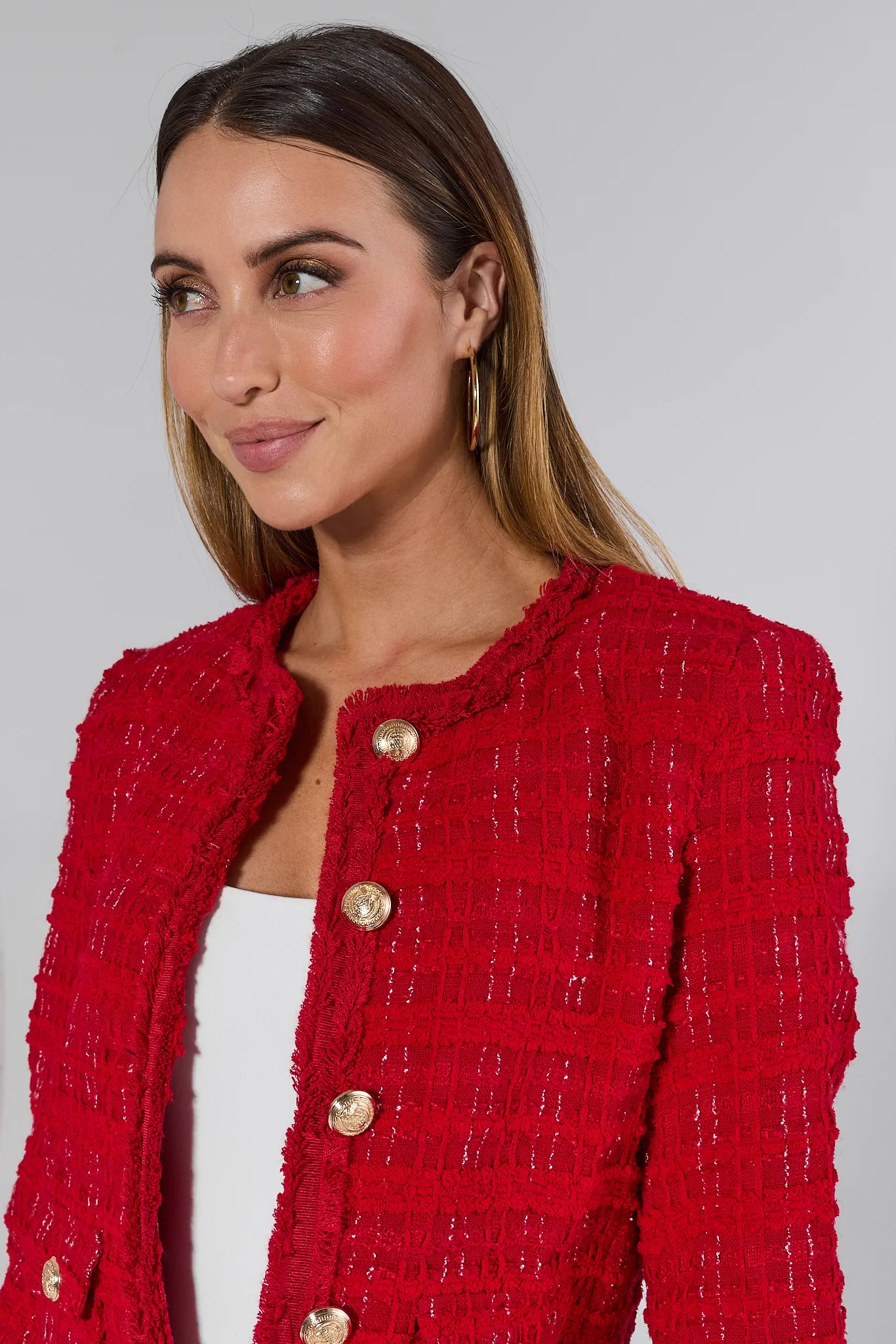Woman wearing a Evelyn Red Tweed Jacket with gold buttons on a plain background