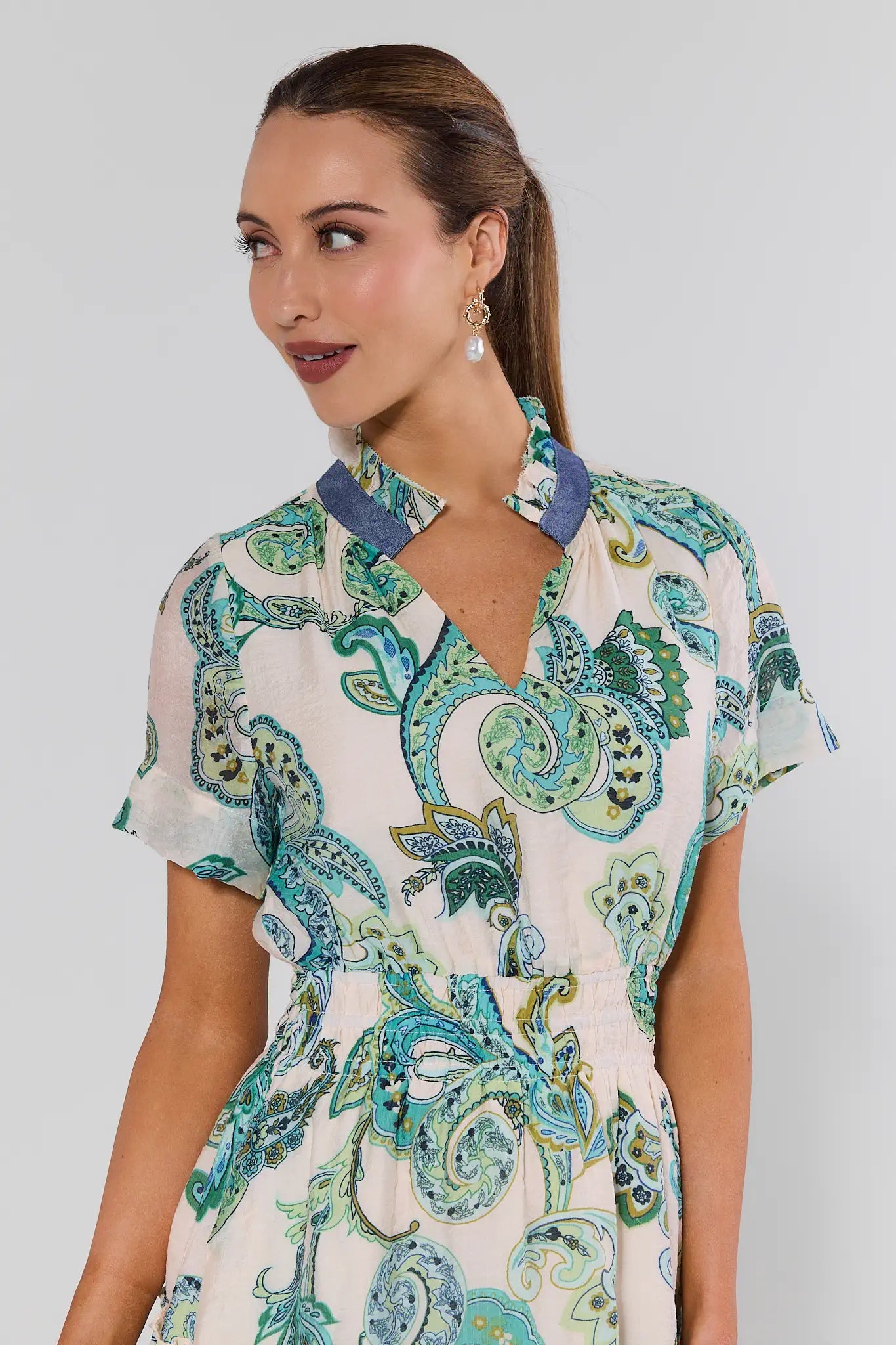 Woman wearing a patterned dress with a plain background