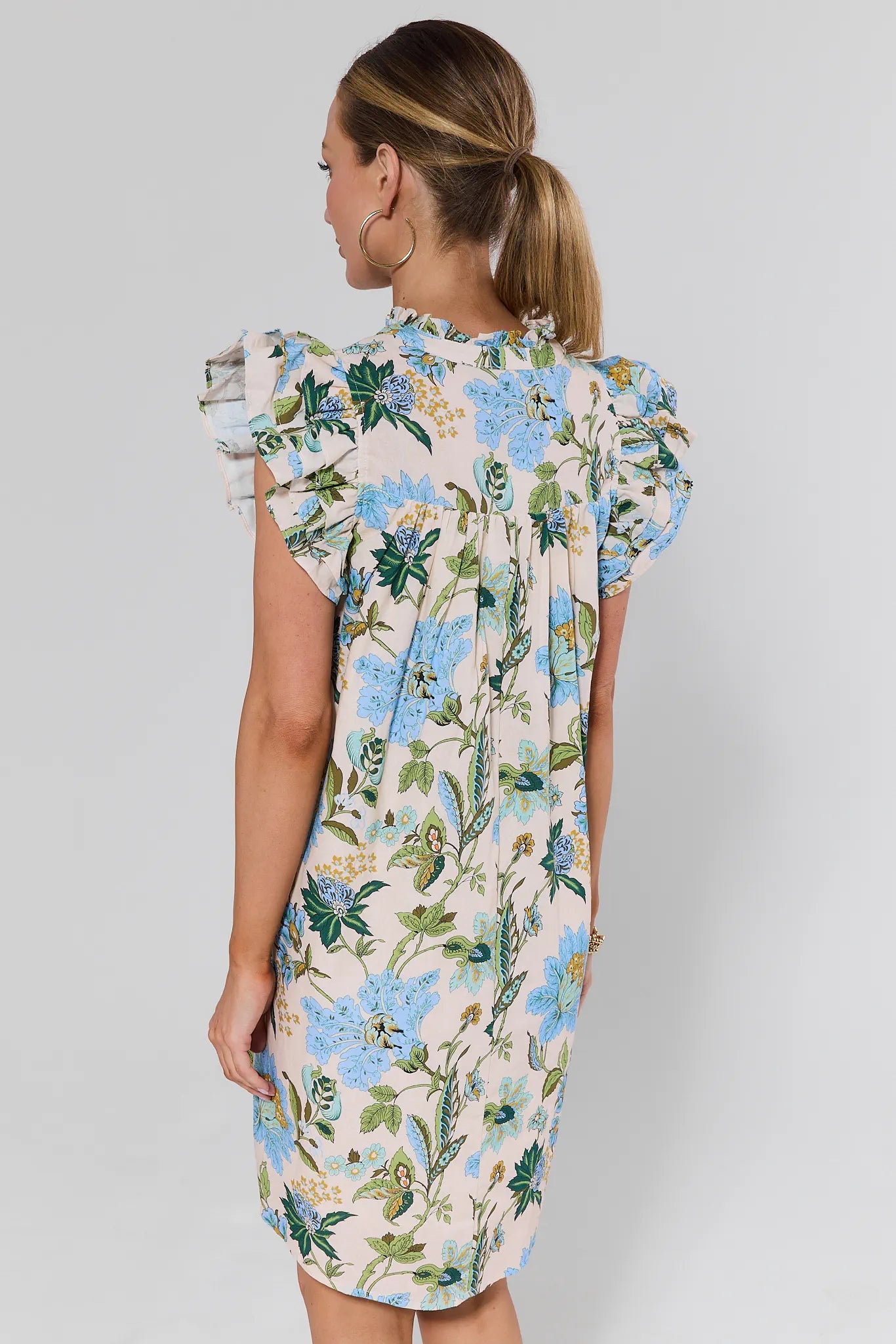 Woman wearing a floral dress against a plain background