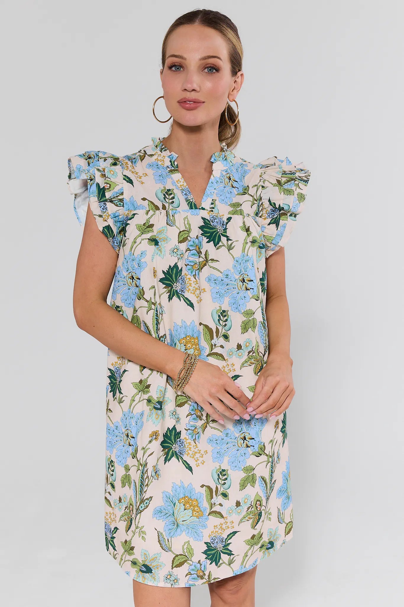 Woman wearing a floral dress against a plain background