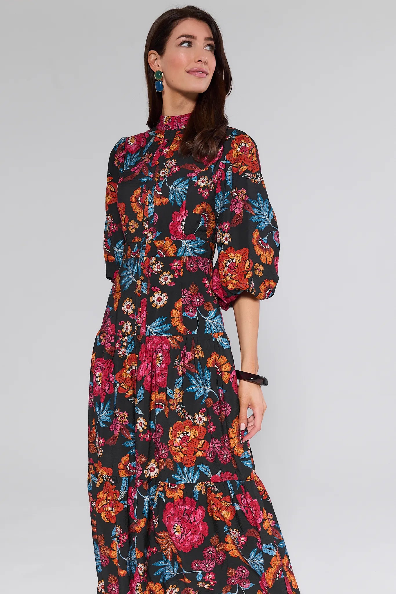 Woman wearing a colorful floral Desi Dress on a white background