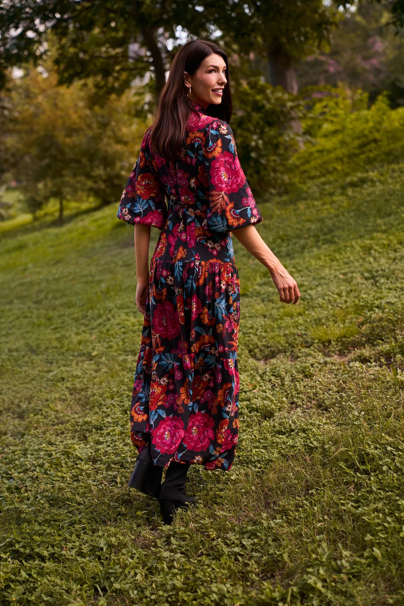 Woman in a colorful floral Desi Dress walking through a grassy field