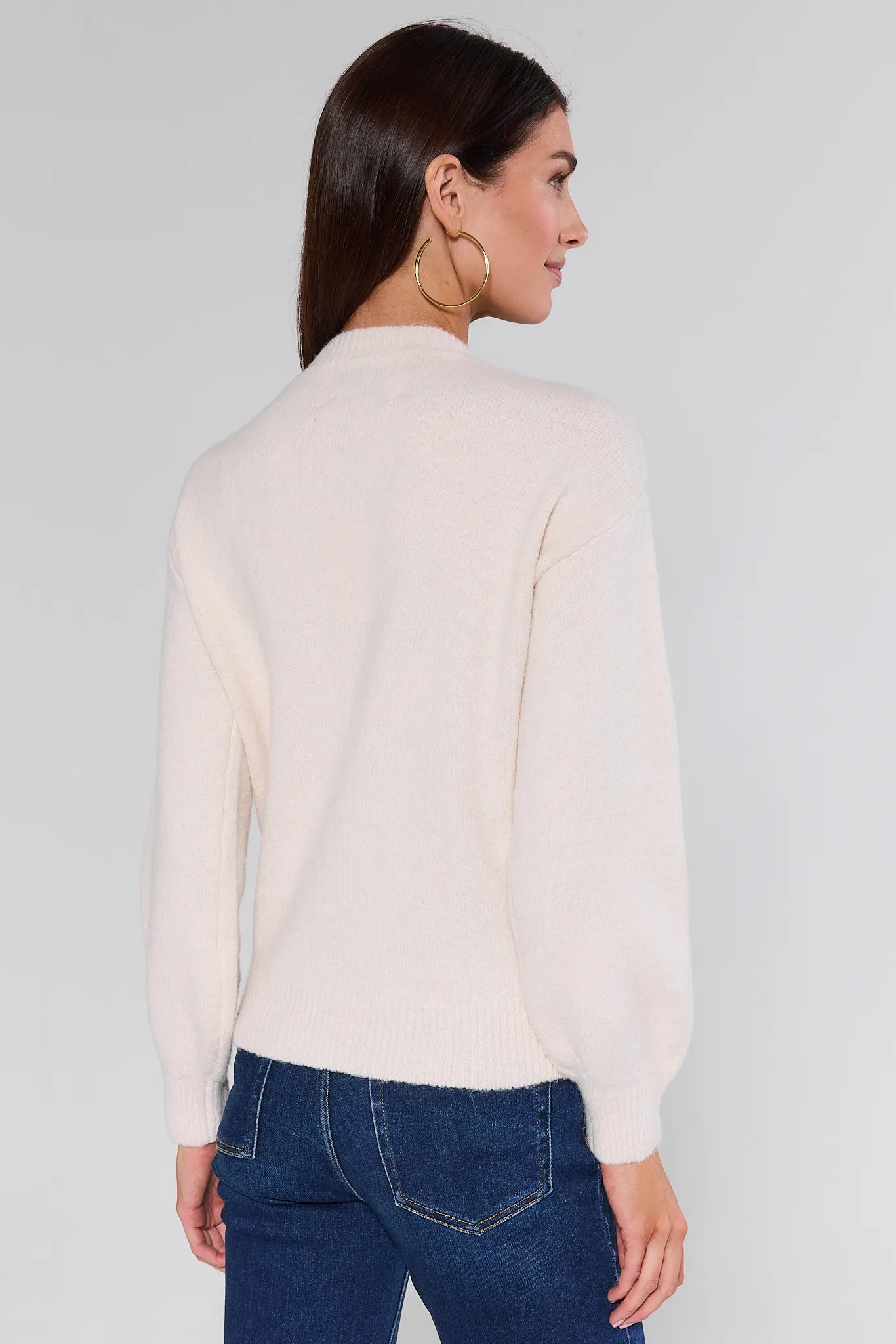 Woman wearing a Stevie Ivory Scarf Sweater with a plain background