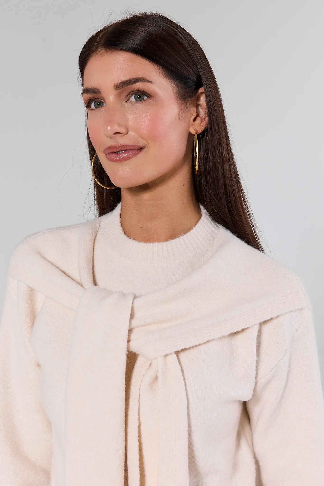 Woman wearing a Stevie Ivory Scarf Sweater with a plain background