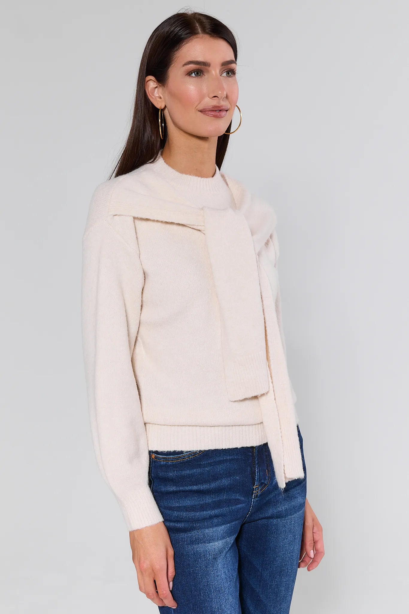 Woman wearing a Stevie Ivory Scarf Sweater with a plain background