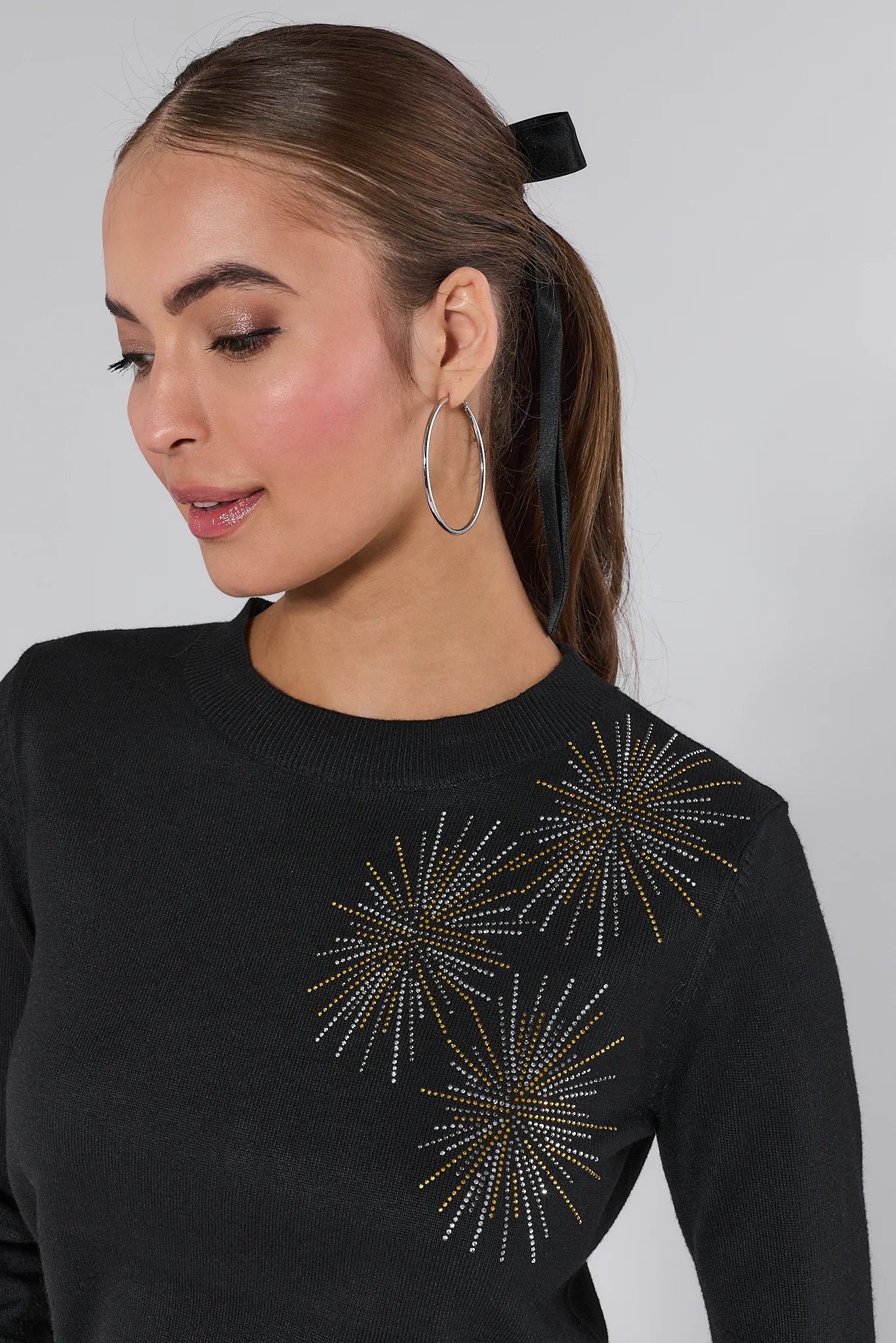 Woman wearing a Ainsley Black Embellished Knit Sweater and silver pants on a white background