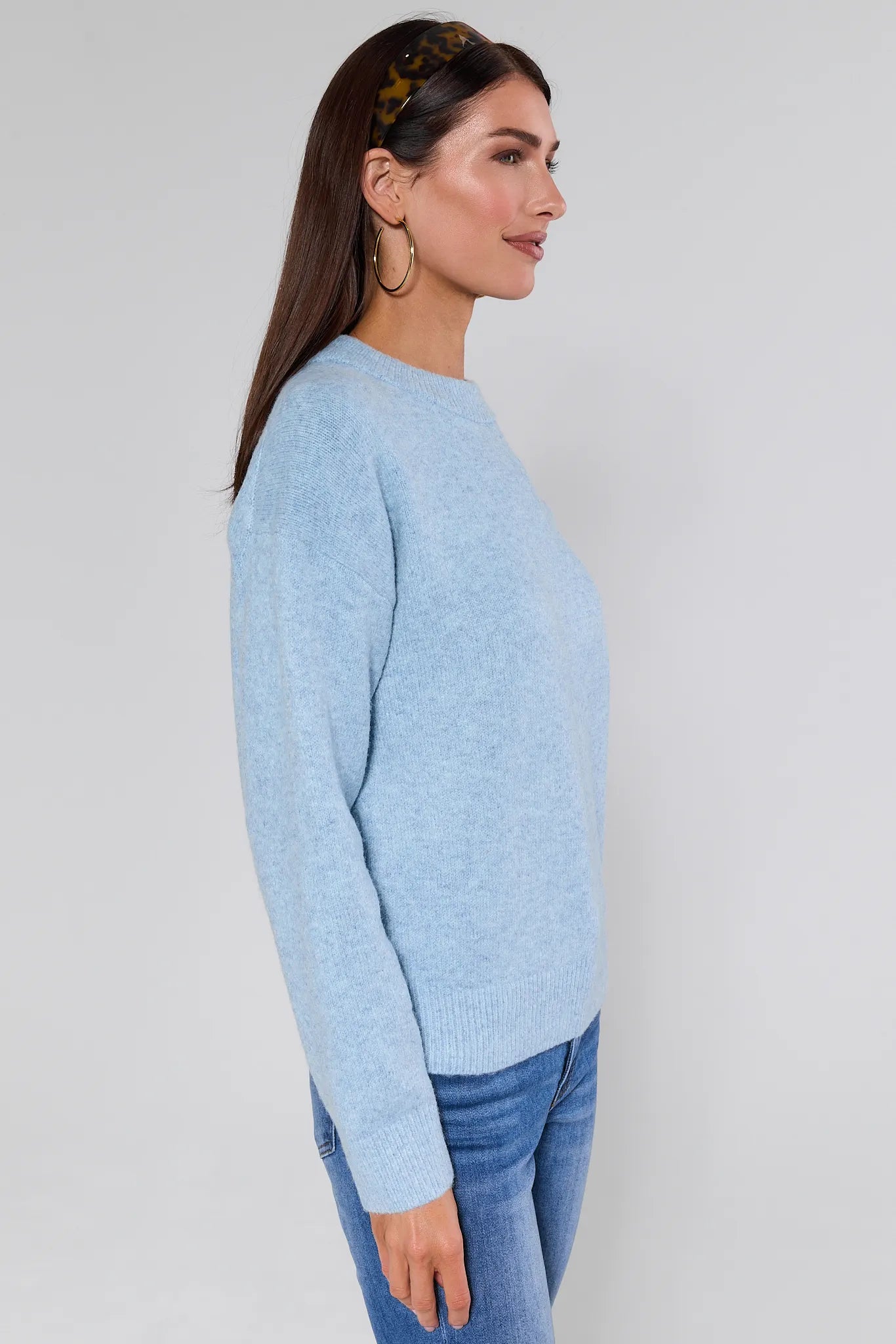 Woman wearing a Natalie Sweater and jeans against a plain background