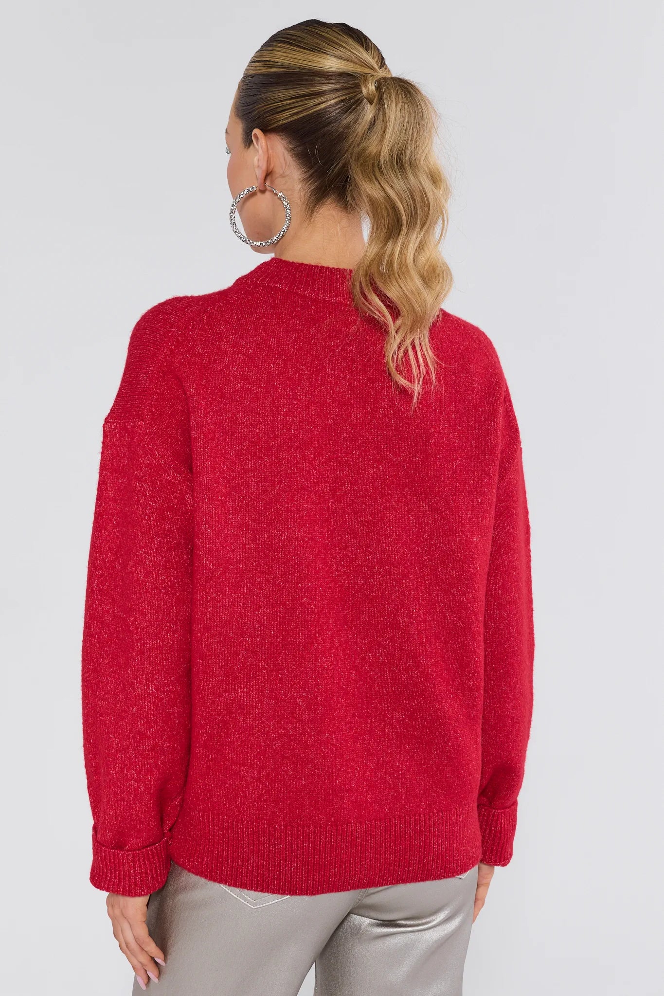 Person wearing a red sweater on a plain background
