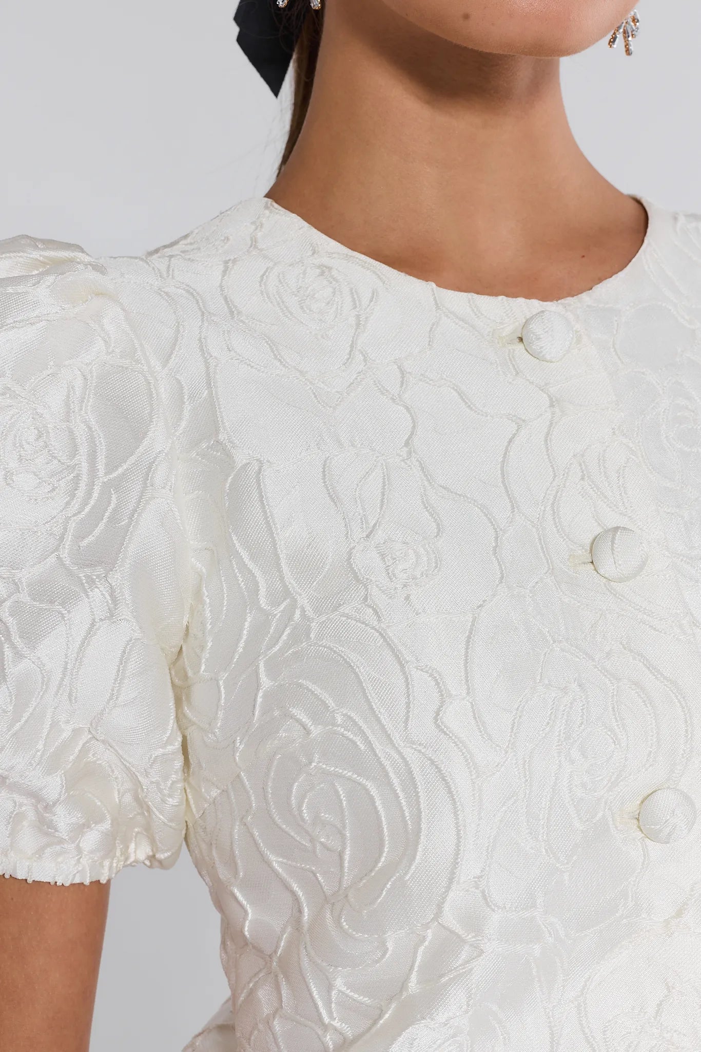 Close-up of a white lace dress with a blurred background