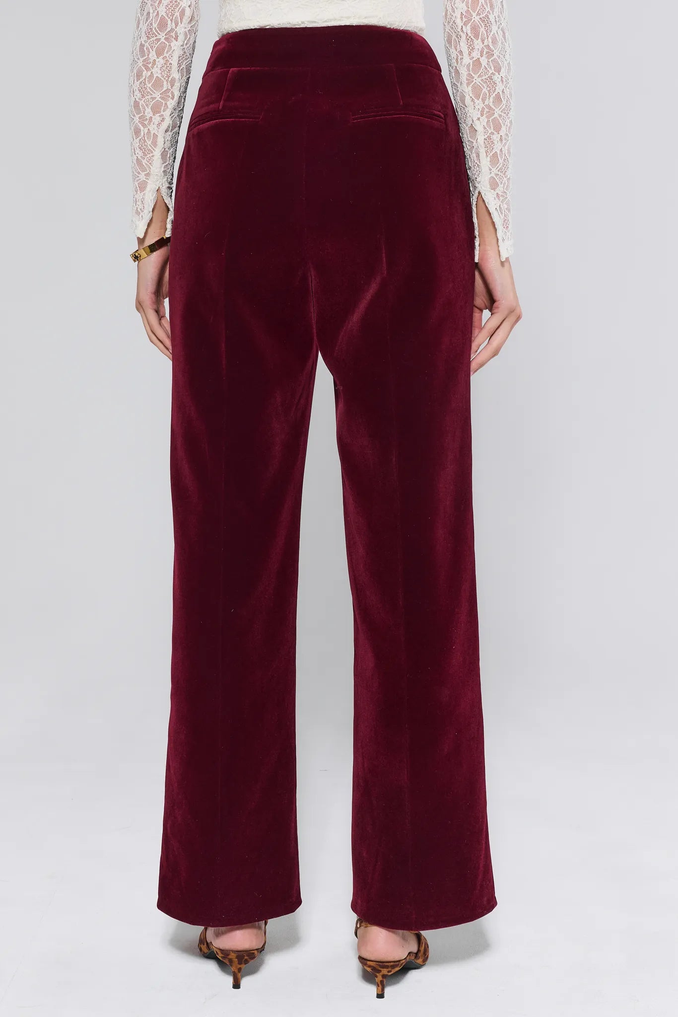 Evie Cranberry Velvet Pants worn by a person on a white background