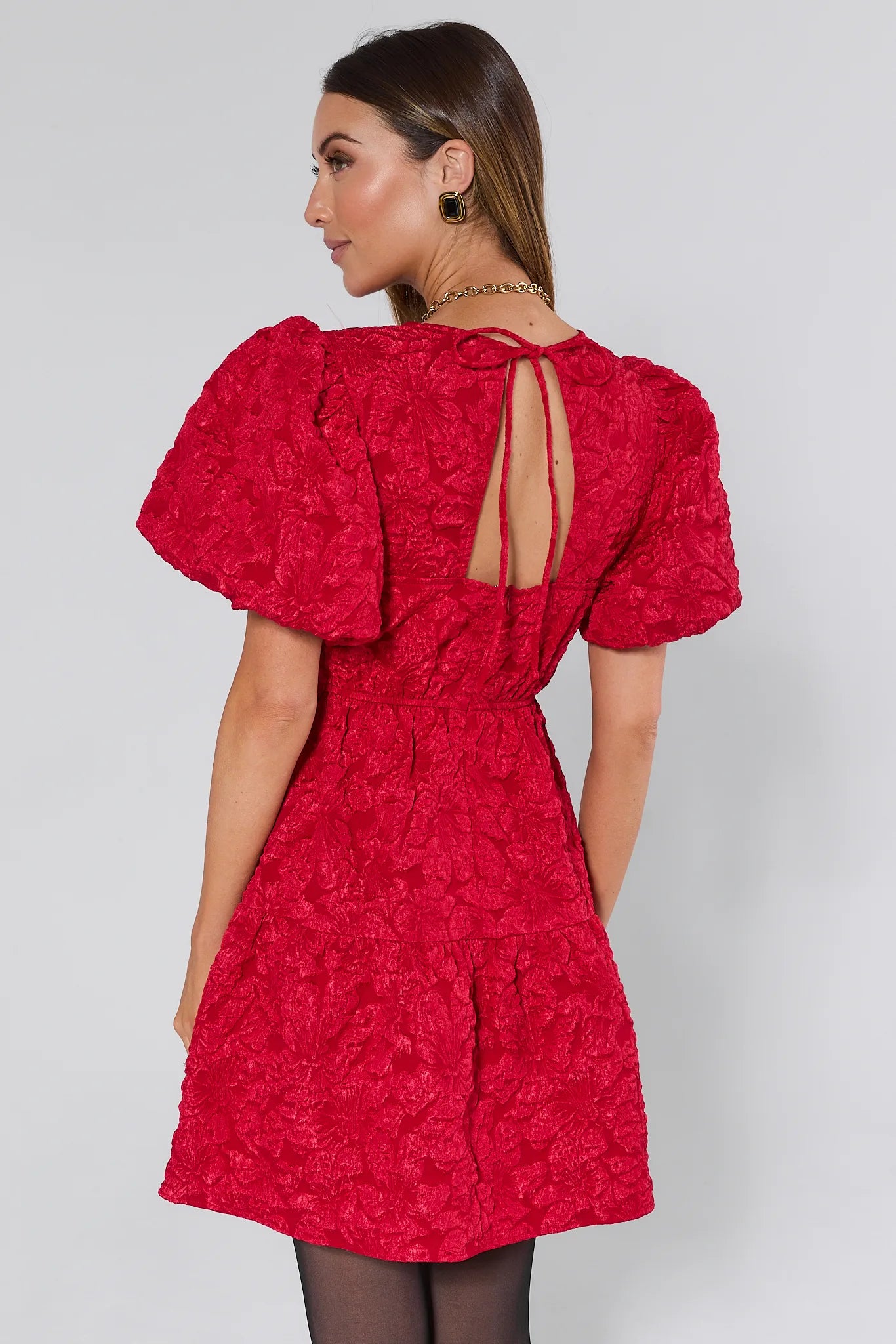 Woman wearing a Teresa Red Floral Short Dress against a white background