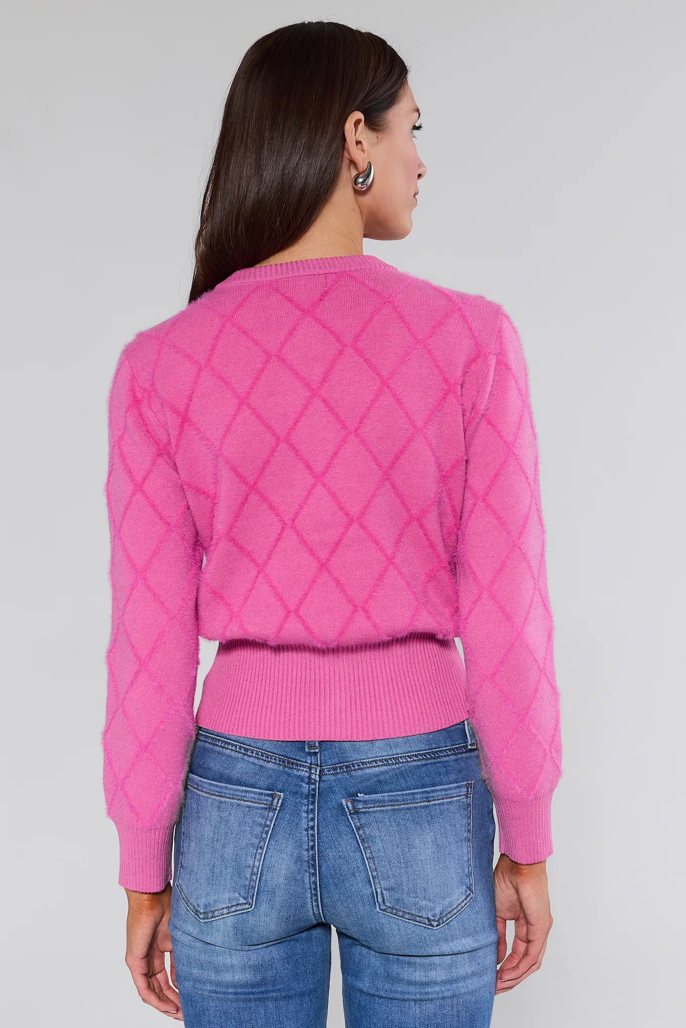 Woman wearing a Emily Pink Bow Cardigan with decorative bows and buttons on a plain background