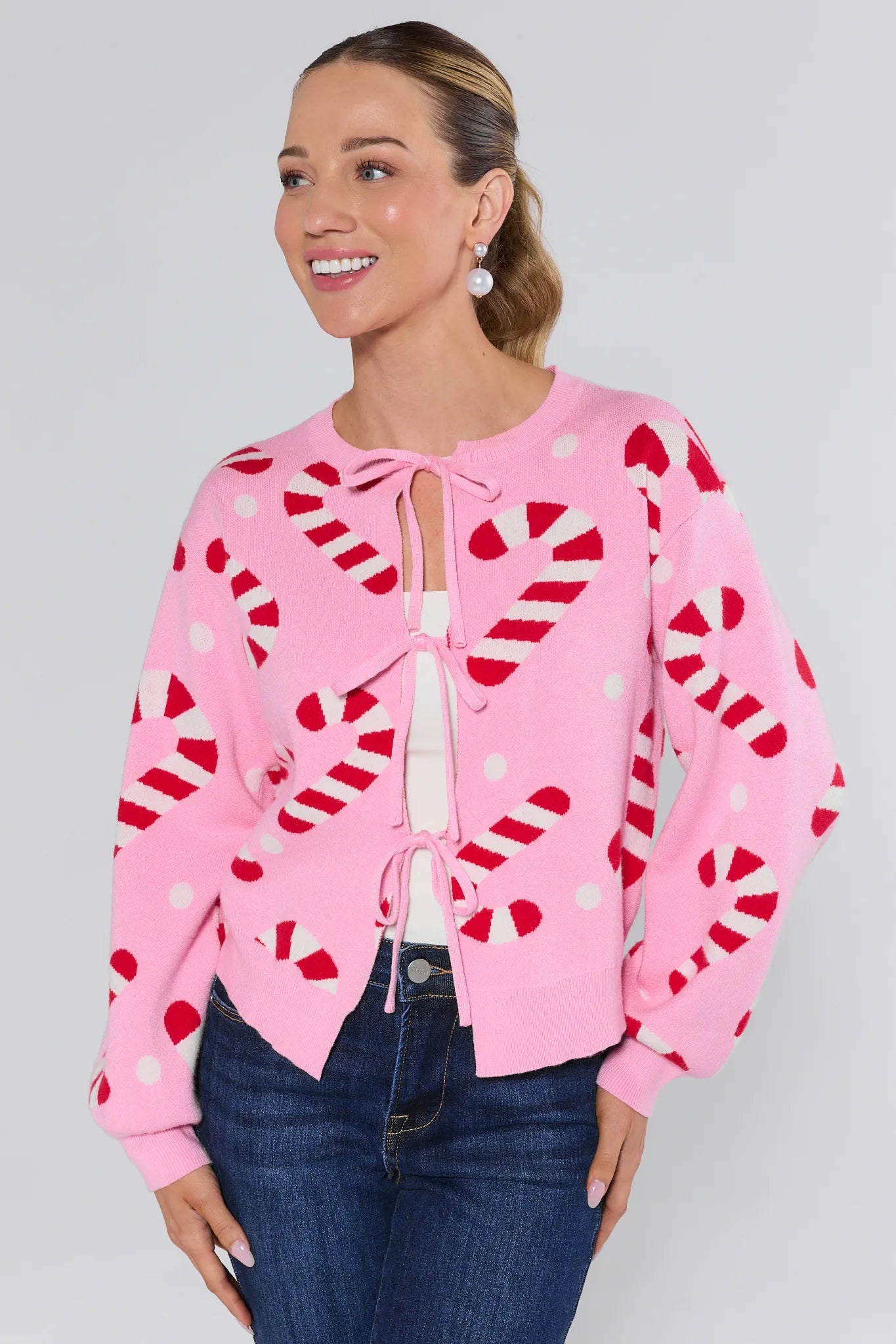 Woman wearing a Hollis Pink Candy Cane Sweater on a plain background