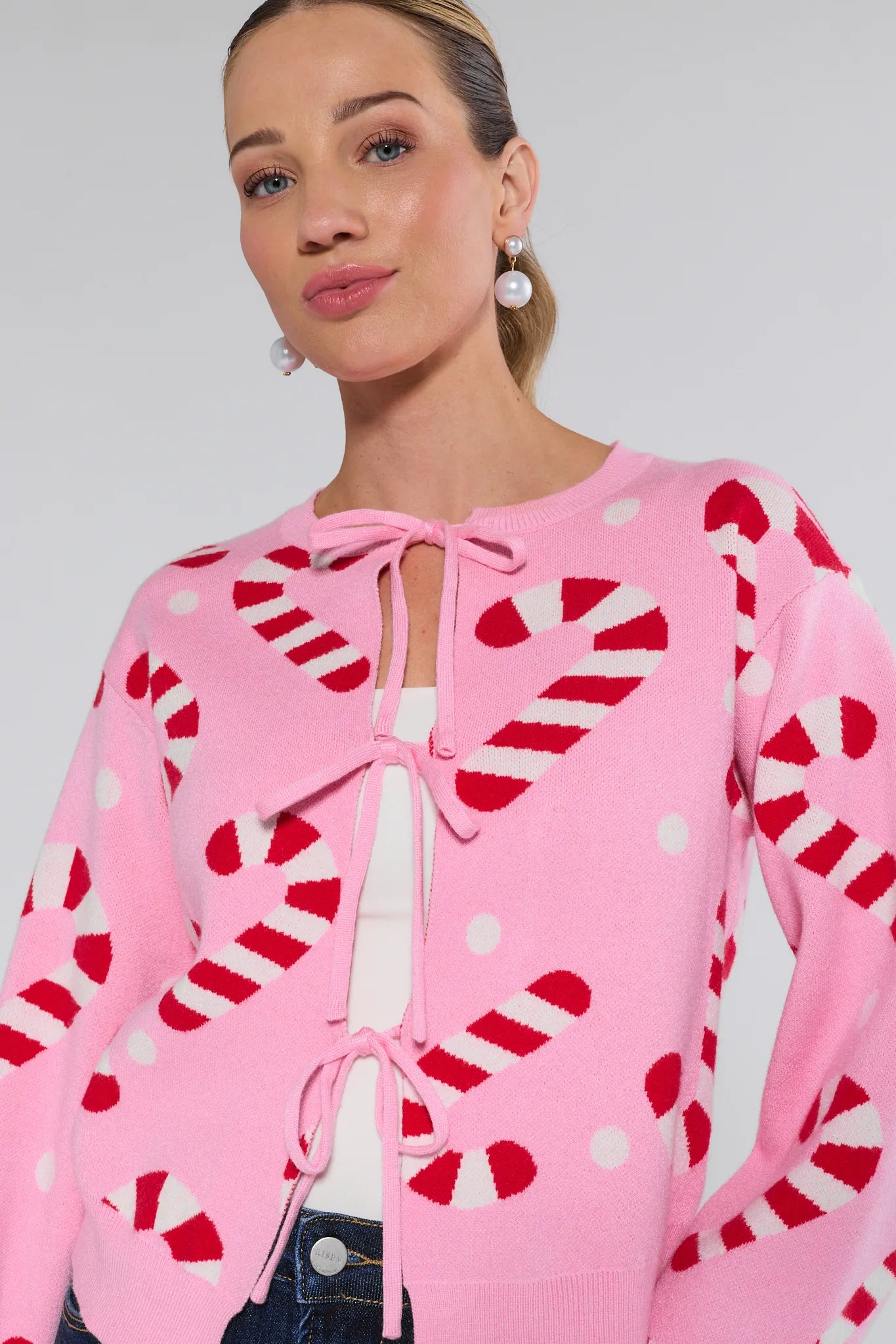Woman wearing a Hollis Pink Candy Cane Sweater on a plain background