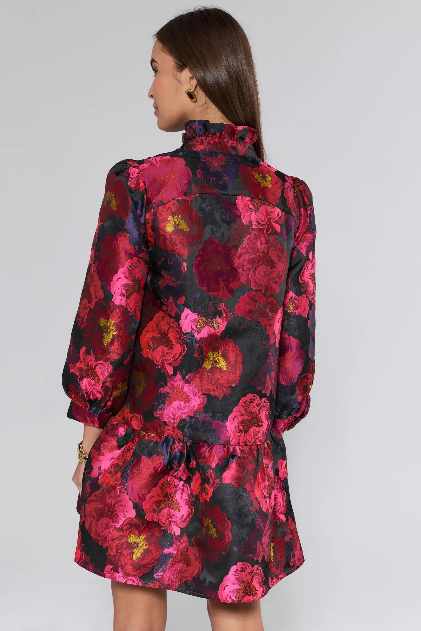 Woman wearing a floral ruby dress with a black background