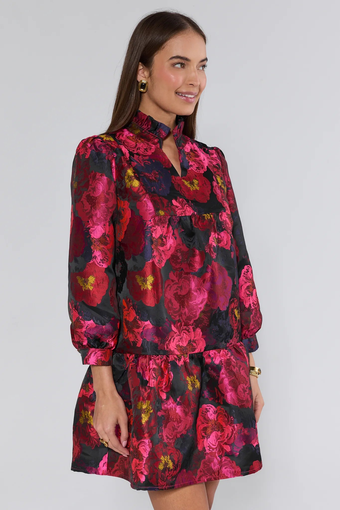 Woman wearing a floral ruby dress with a black background