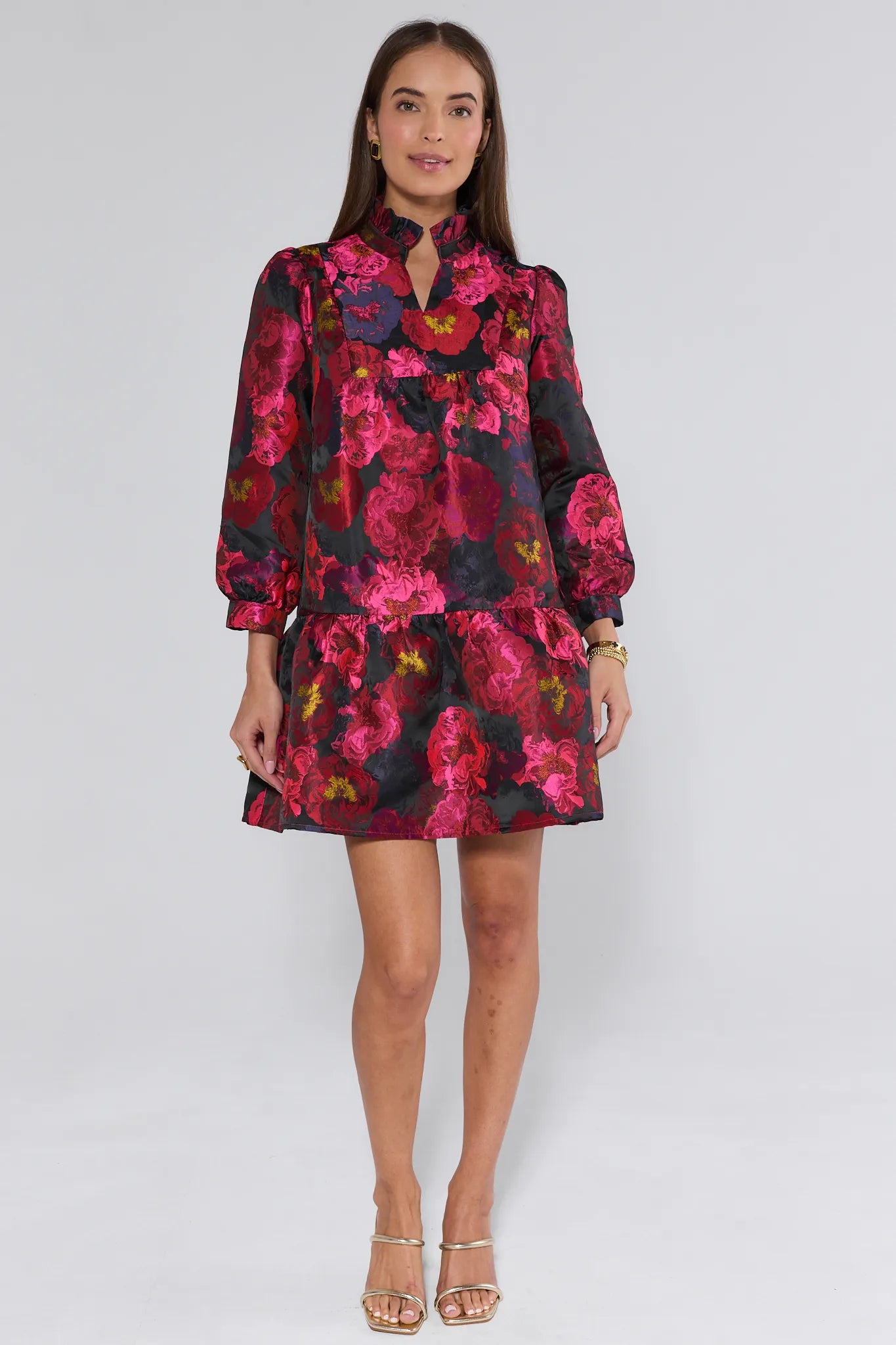 Woman wearing a floral ruby dress with a black background