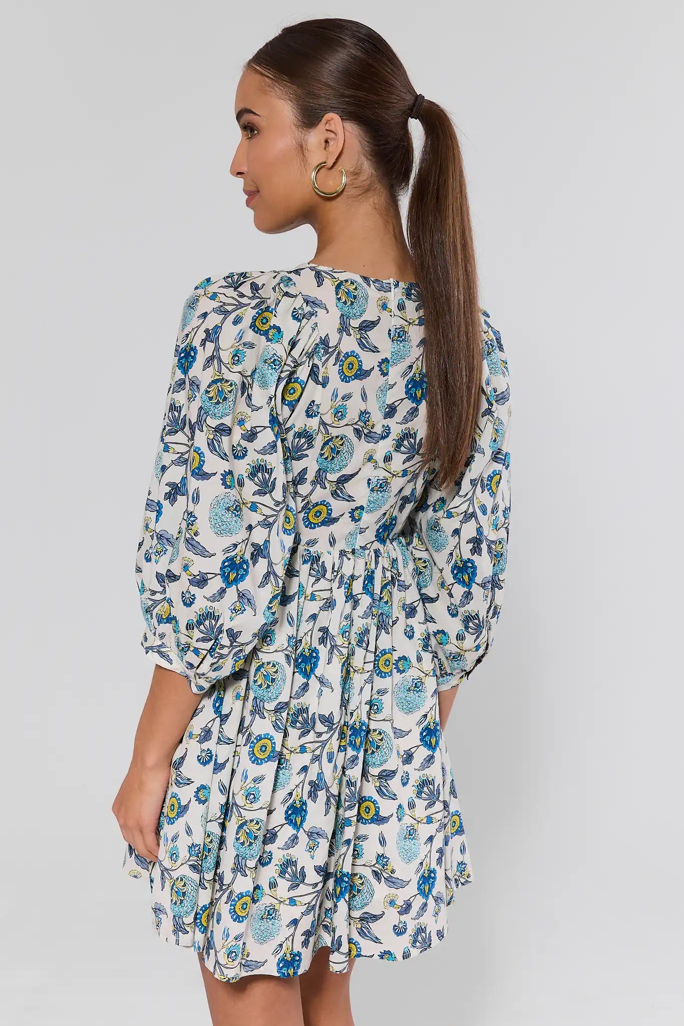 Woman wearing a floral dress against a plain background