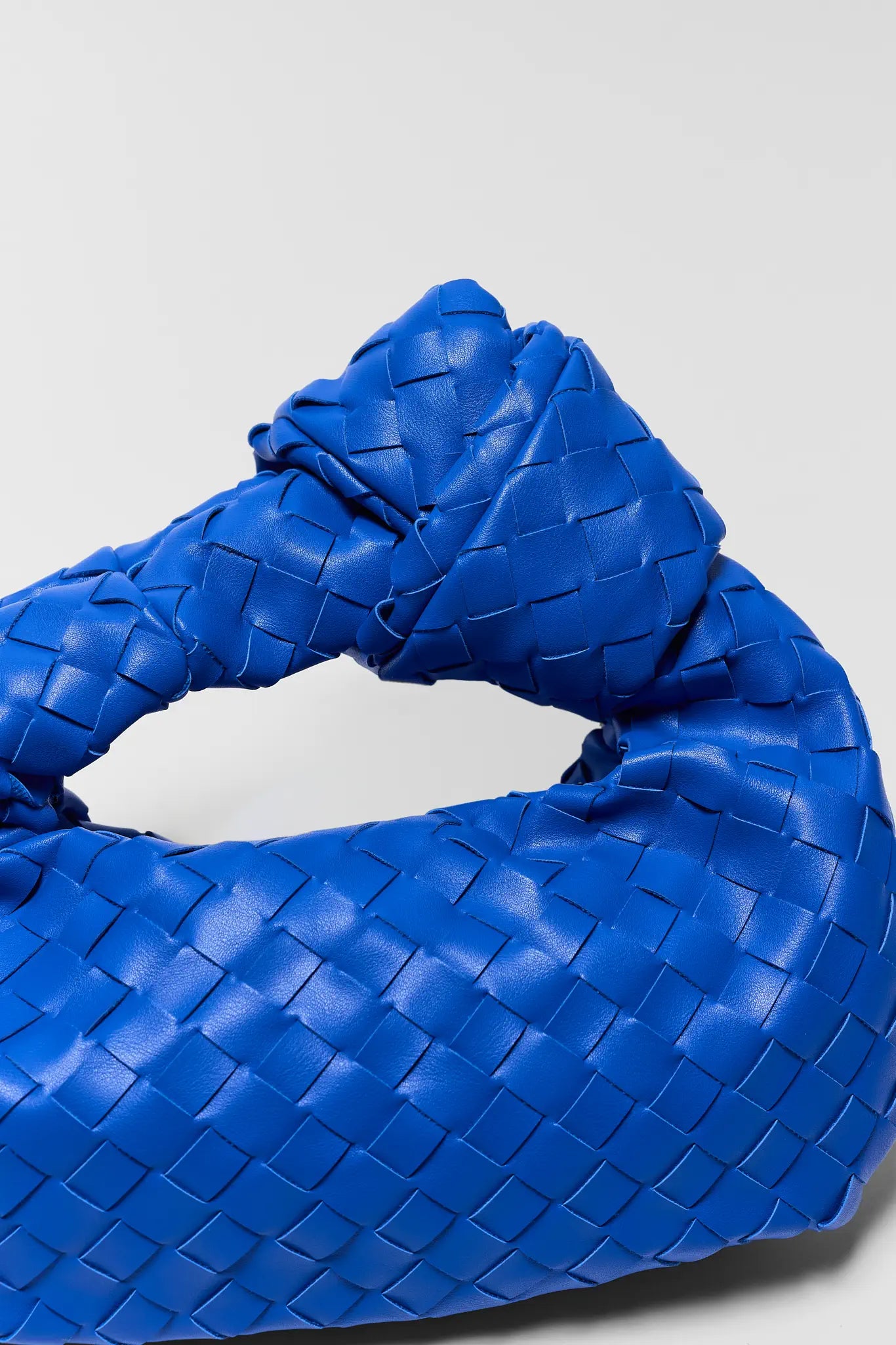 Blue woven handbag on a light gray background