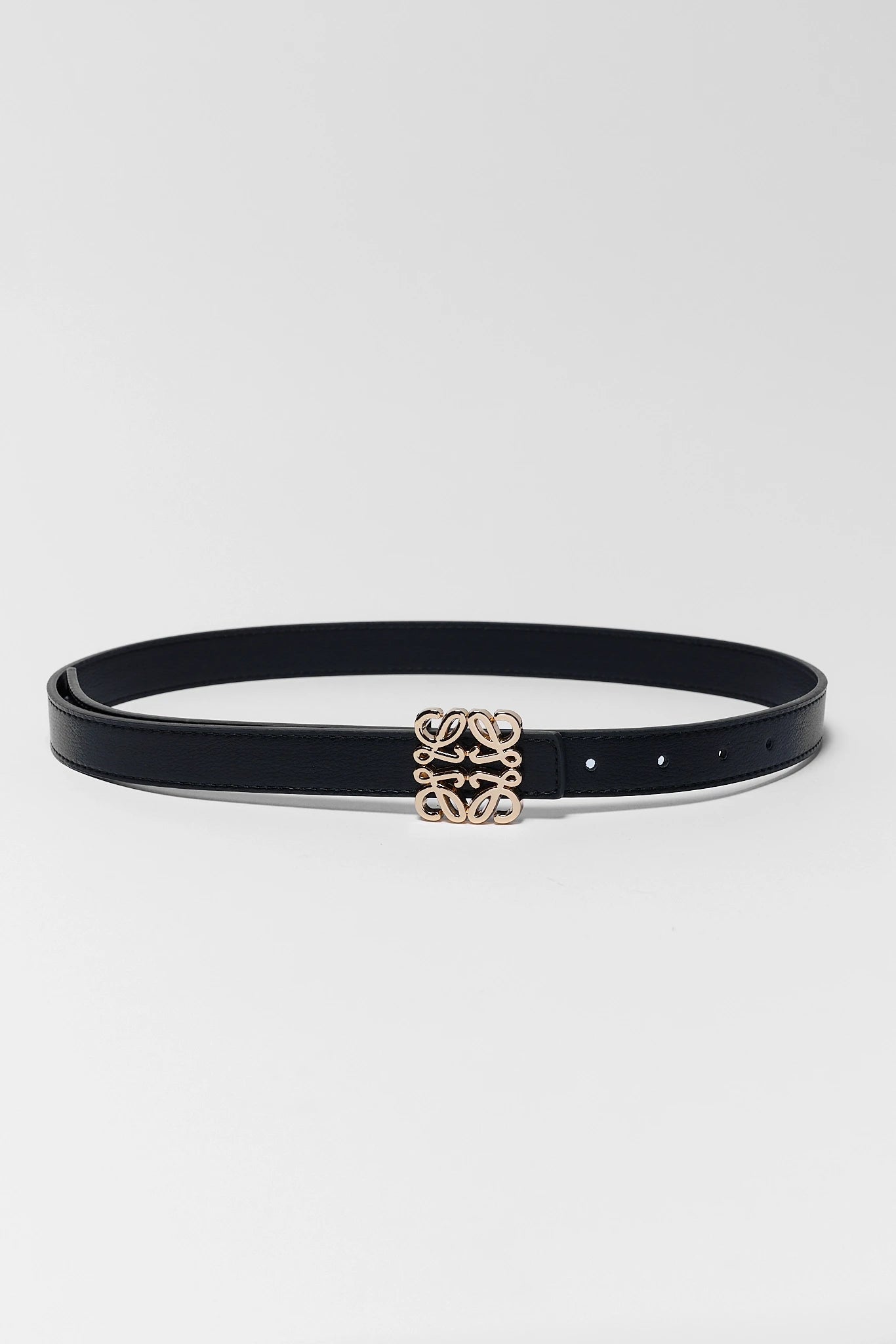 Black rowan belt with a gold buckle on a white background