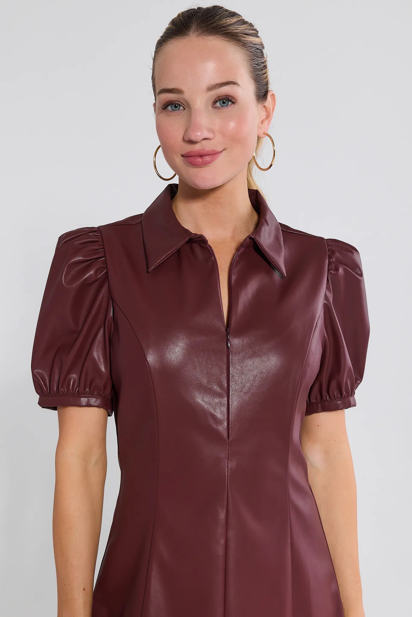 Woman wearing a burgundy leather Harley Dress with puffed sleeves on a white background