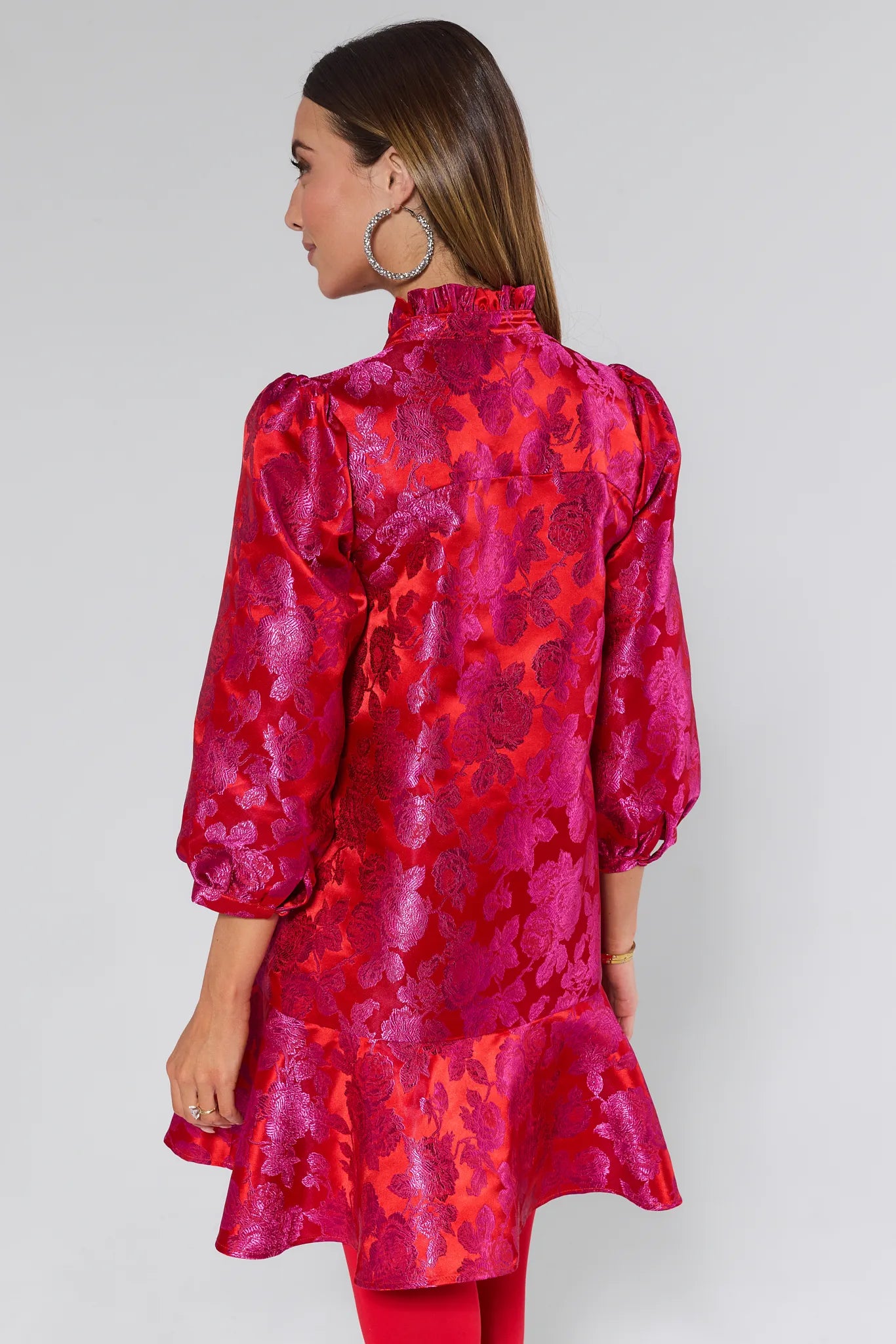 Woman wearing a vibrant Alyssa Brocade Drop Waist Dress against a white background