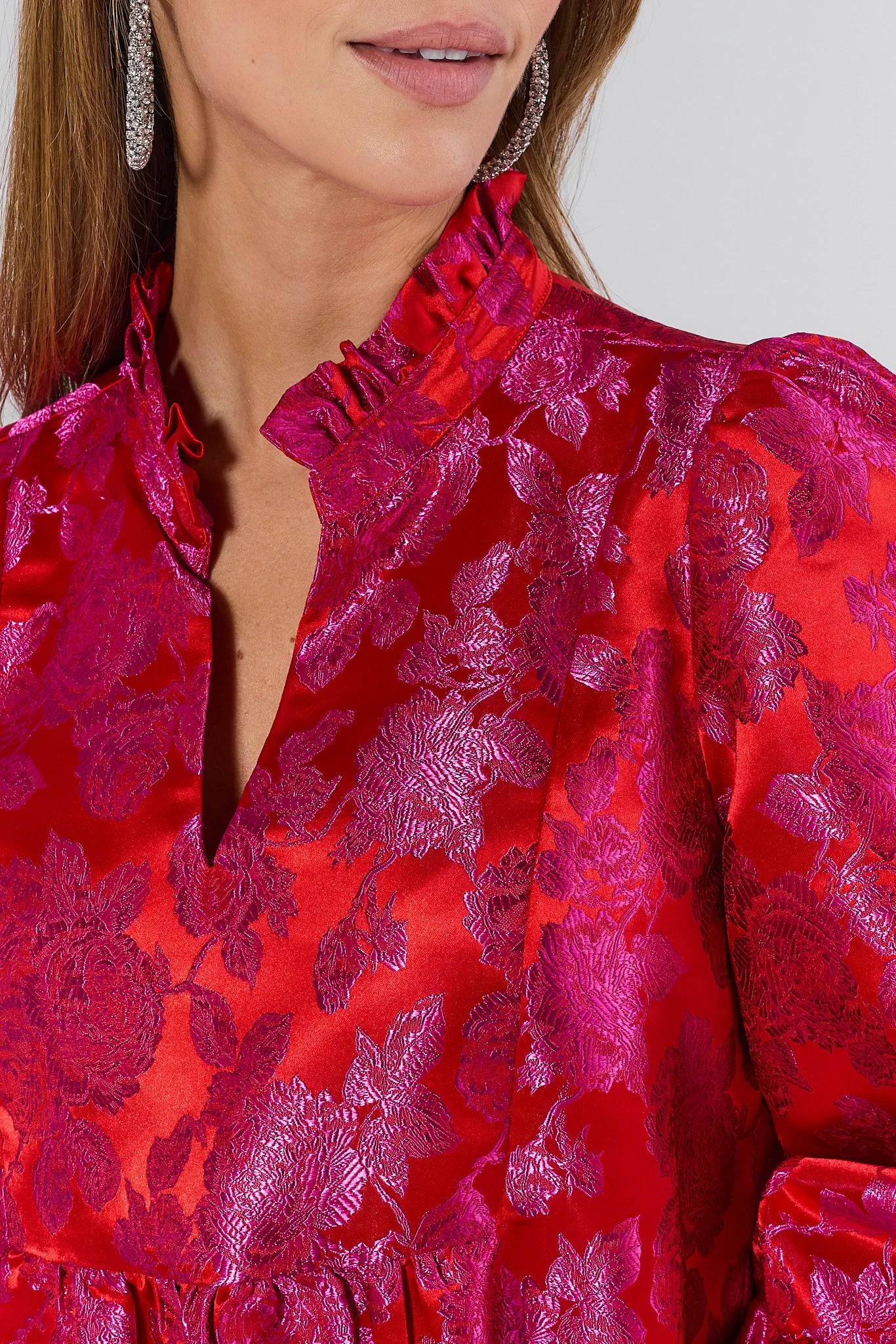 Woman wearing a vibrant Alyssa Brocade Drop Waist Dress against a white background