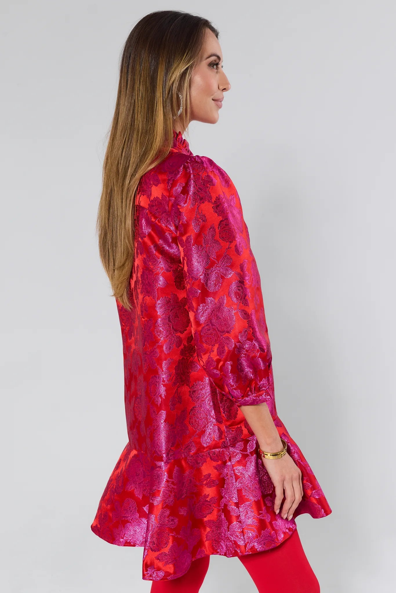 Woman wearing a vibrant Alyssa Brocade Drop Waist Dress against a white background