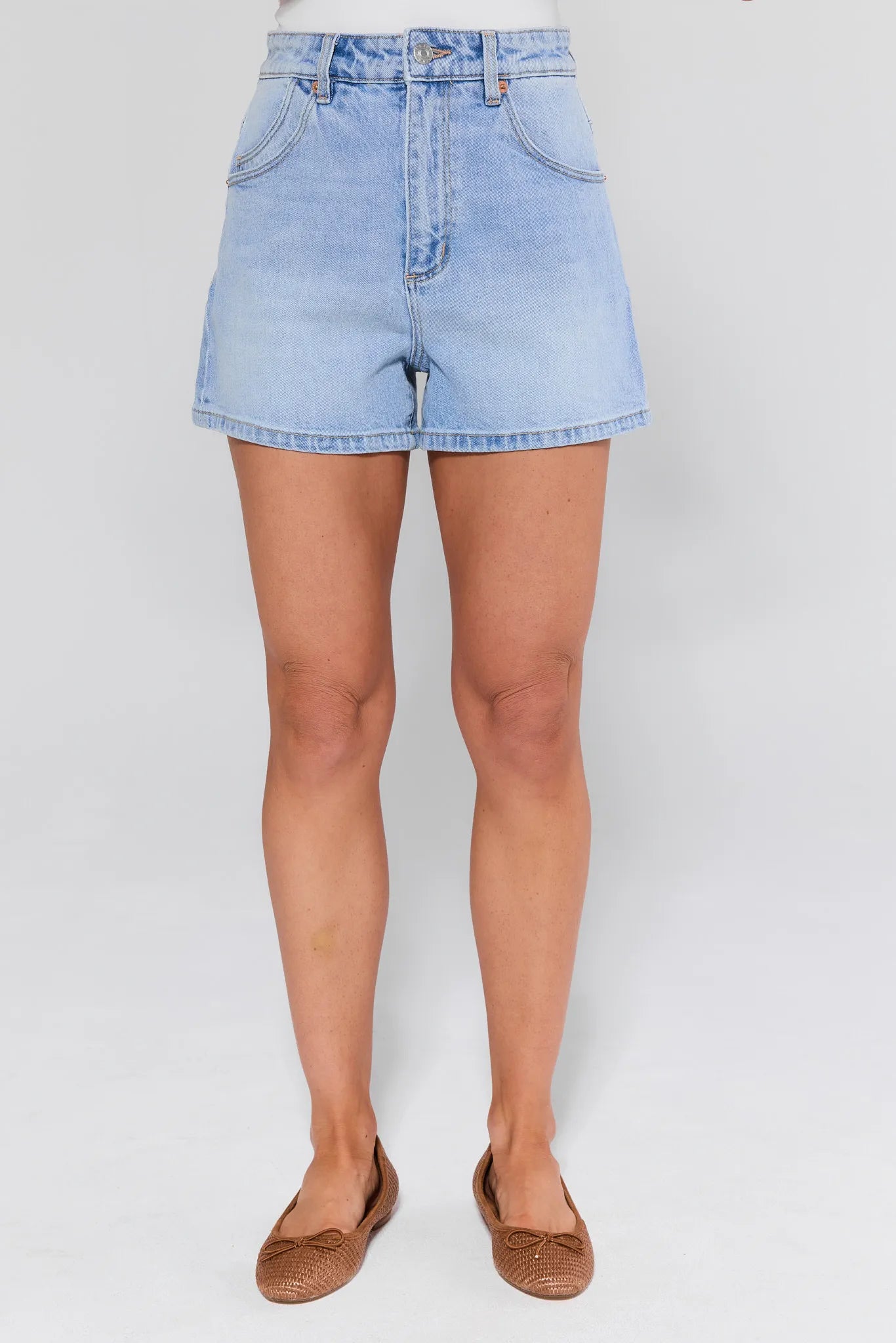 Light blue denim shorts worn by a woman on a white background