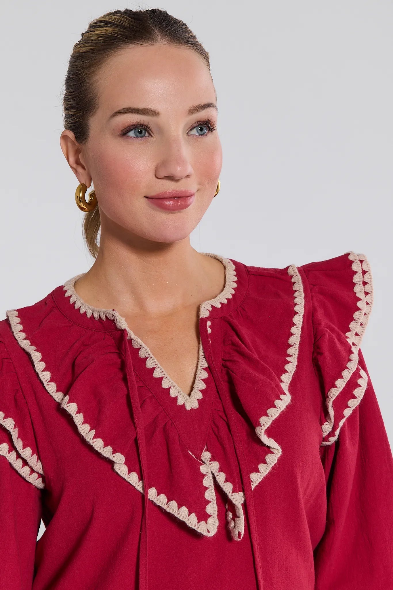 Woman wearing a red Viviana Top with white trim against a plain background