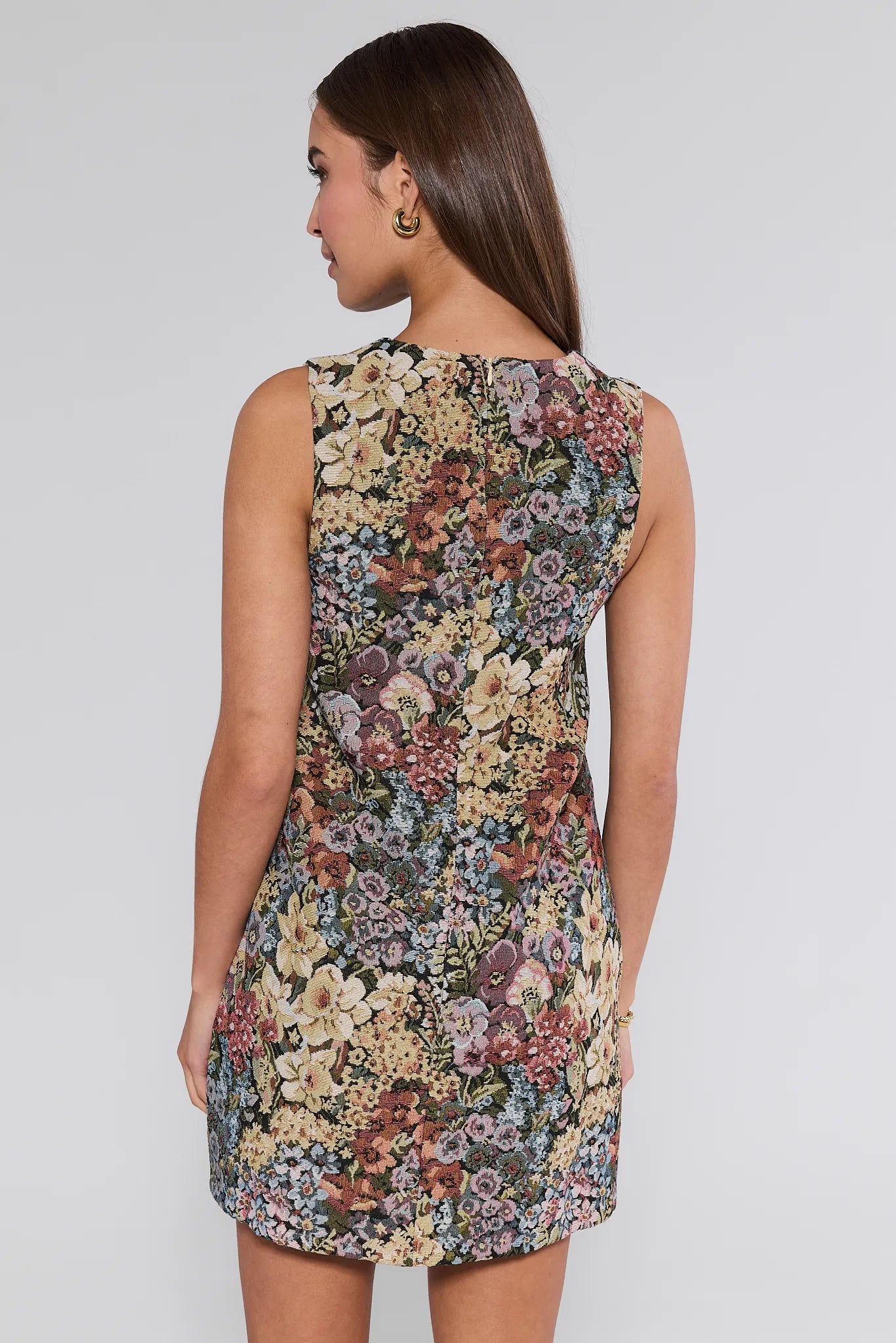 Woman wearing a sleeveless floral Camdyn Dress against a plain background