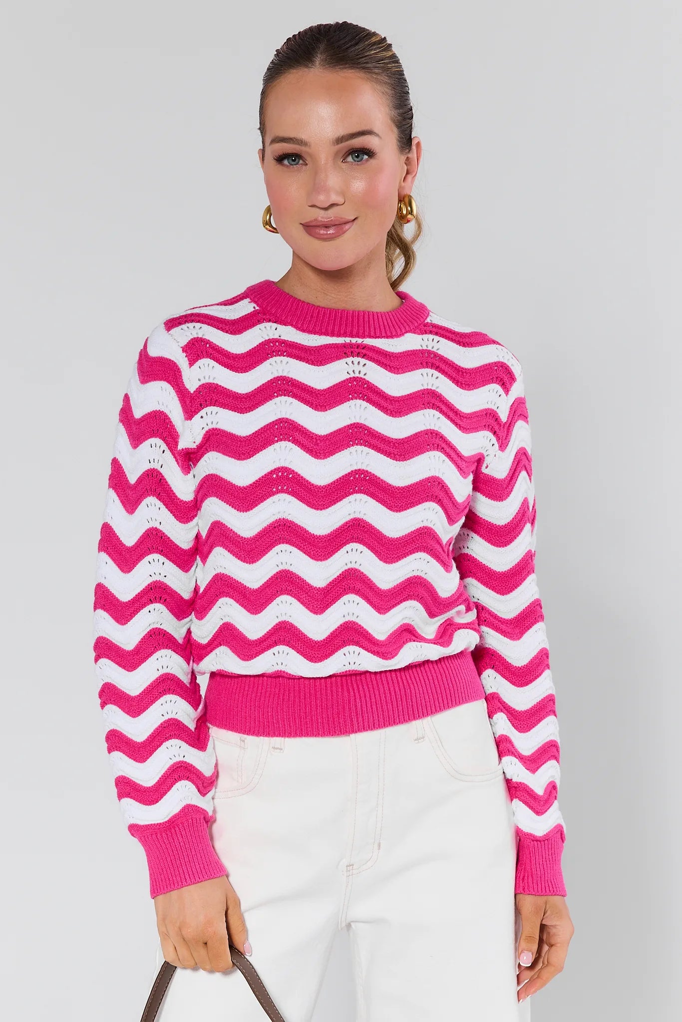 Woman wearing a Eliana Pink Chevron Knit Sweater against a plain background